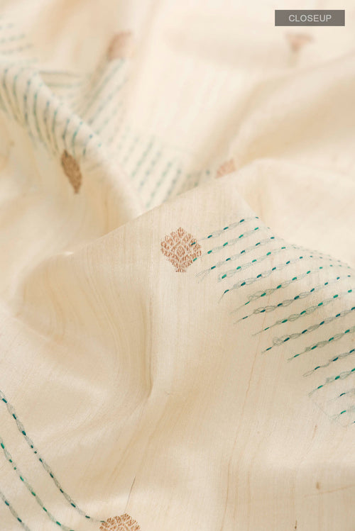 Close up of Beige Bhagalpuri Tussar Silk Saree with Zari Butta on the body and Embroidery Border displaying folds