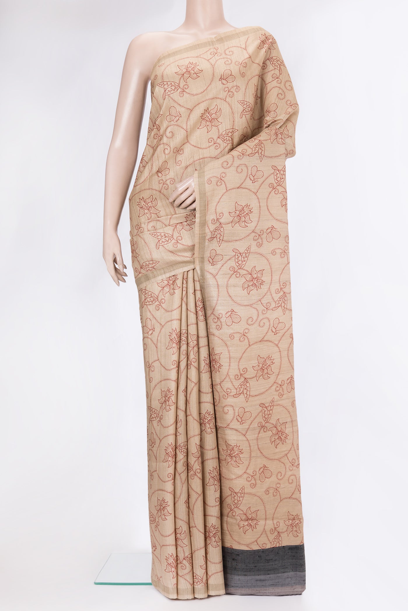 Beige Tussar Silk Saree with Printed design on the body and Zari Border.  displayed on a mannequin