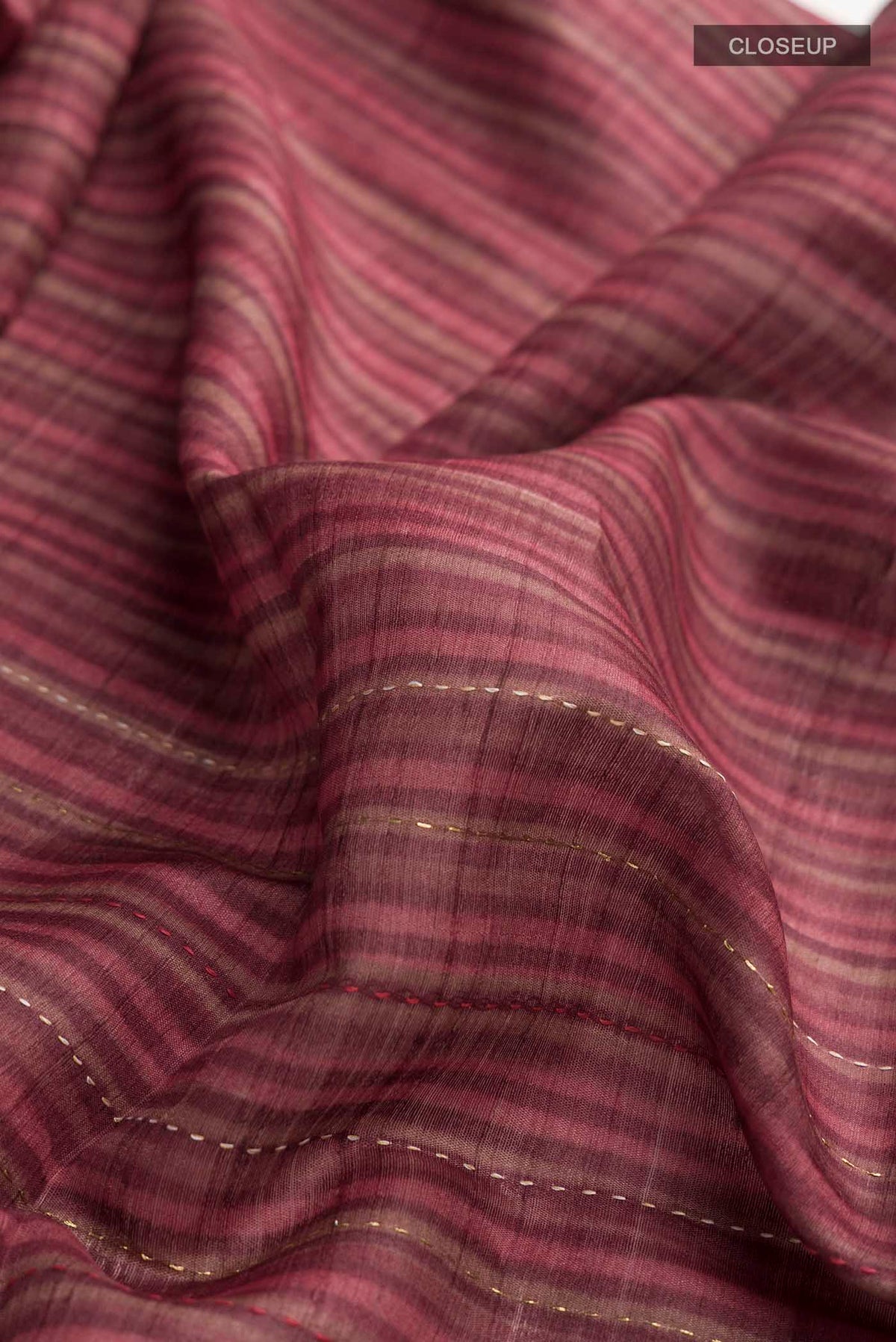 Close up of Maroon Bhagalpuri Tussar Silk Saree with Embroidery on the body and Zari Border displaying folds