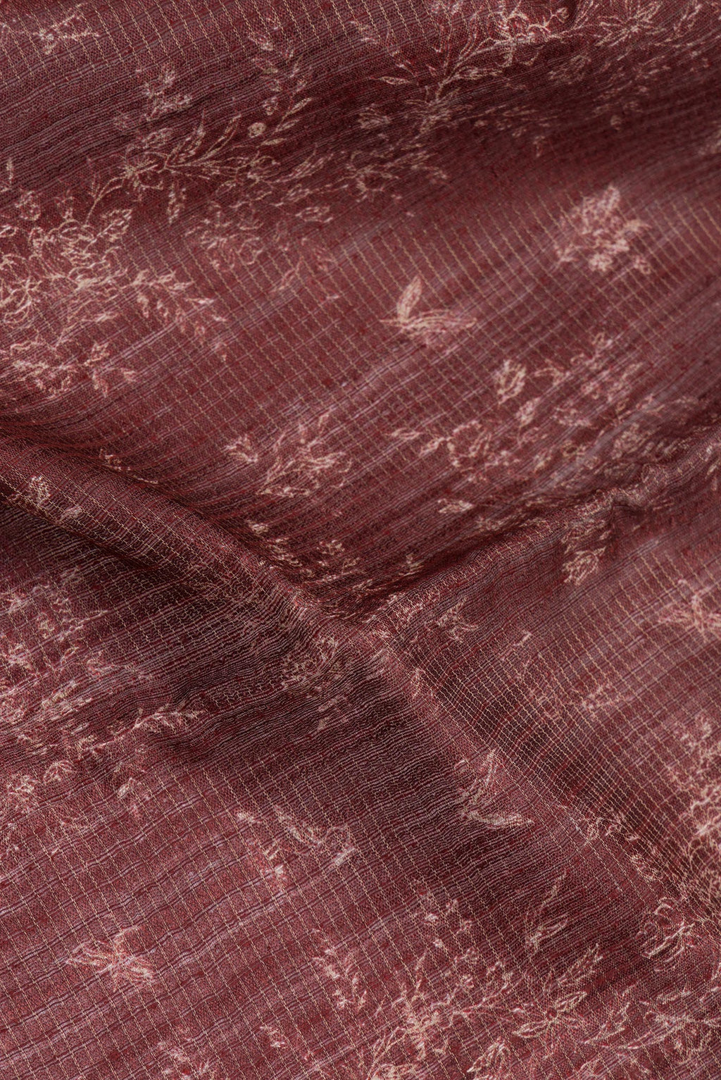 Close up of Brown Tussar Silk Saree with Printed design on the body and Zari Border.  displaying folds