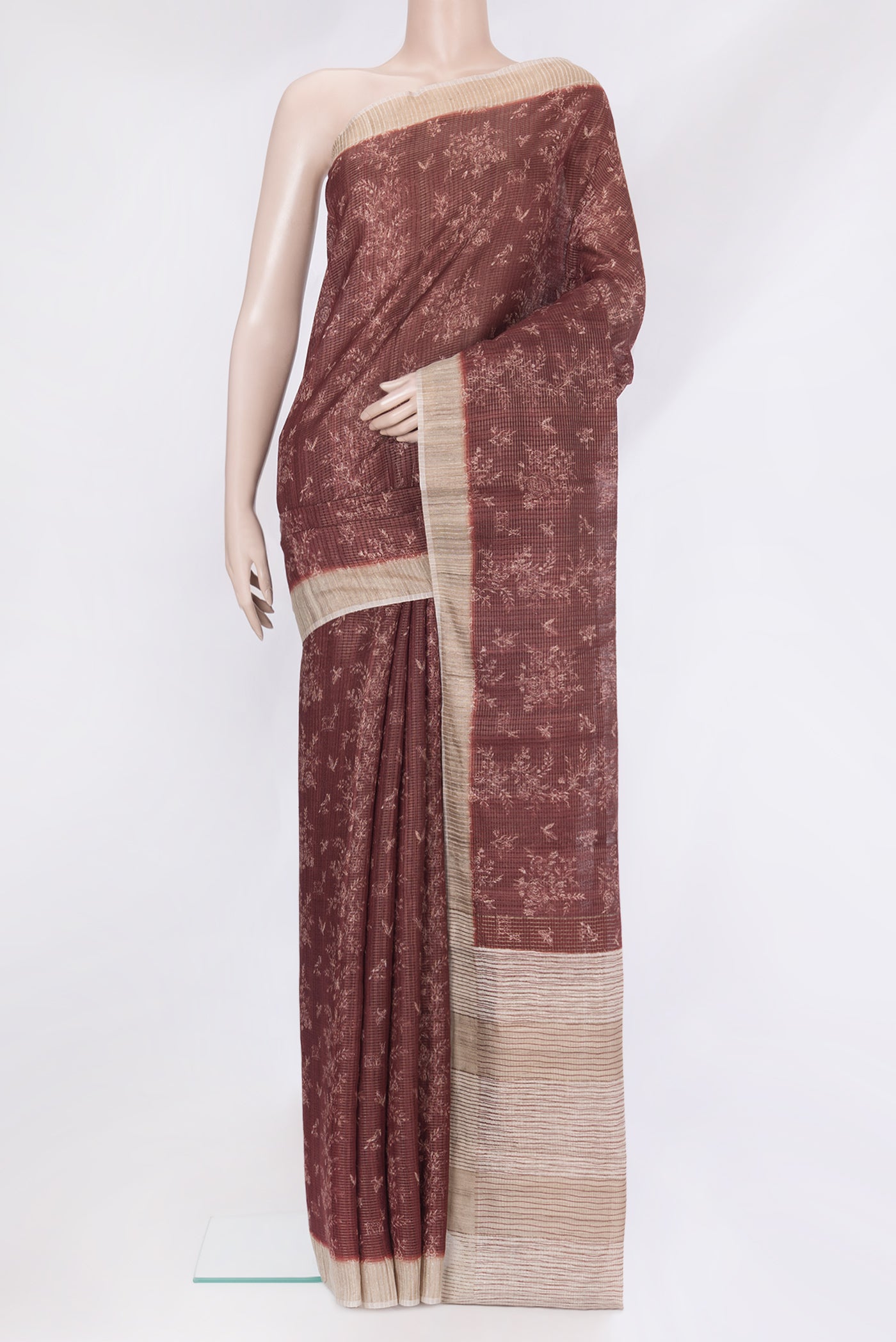Brown Tussar Silk Saree with Printed design on the body and Zari Border.  displayed on a mannequin