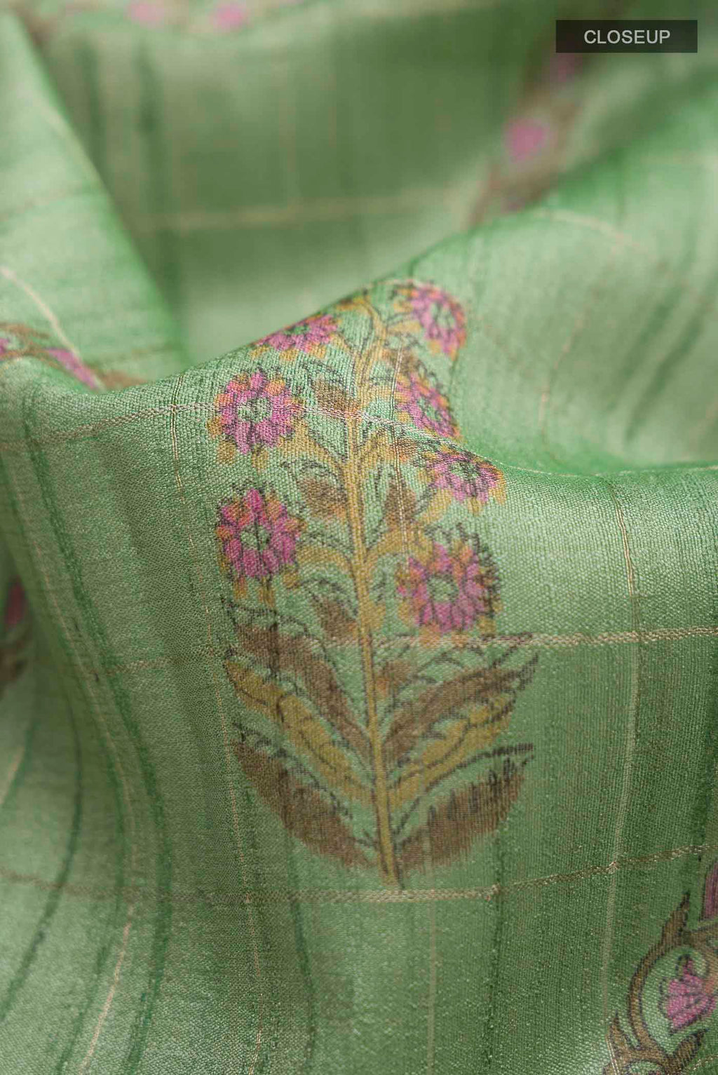 Close up of Green Tussar Silk Saree with Stripes on the body and Printed Border displaying folds