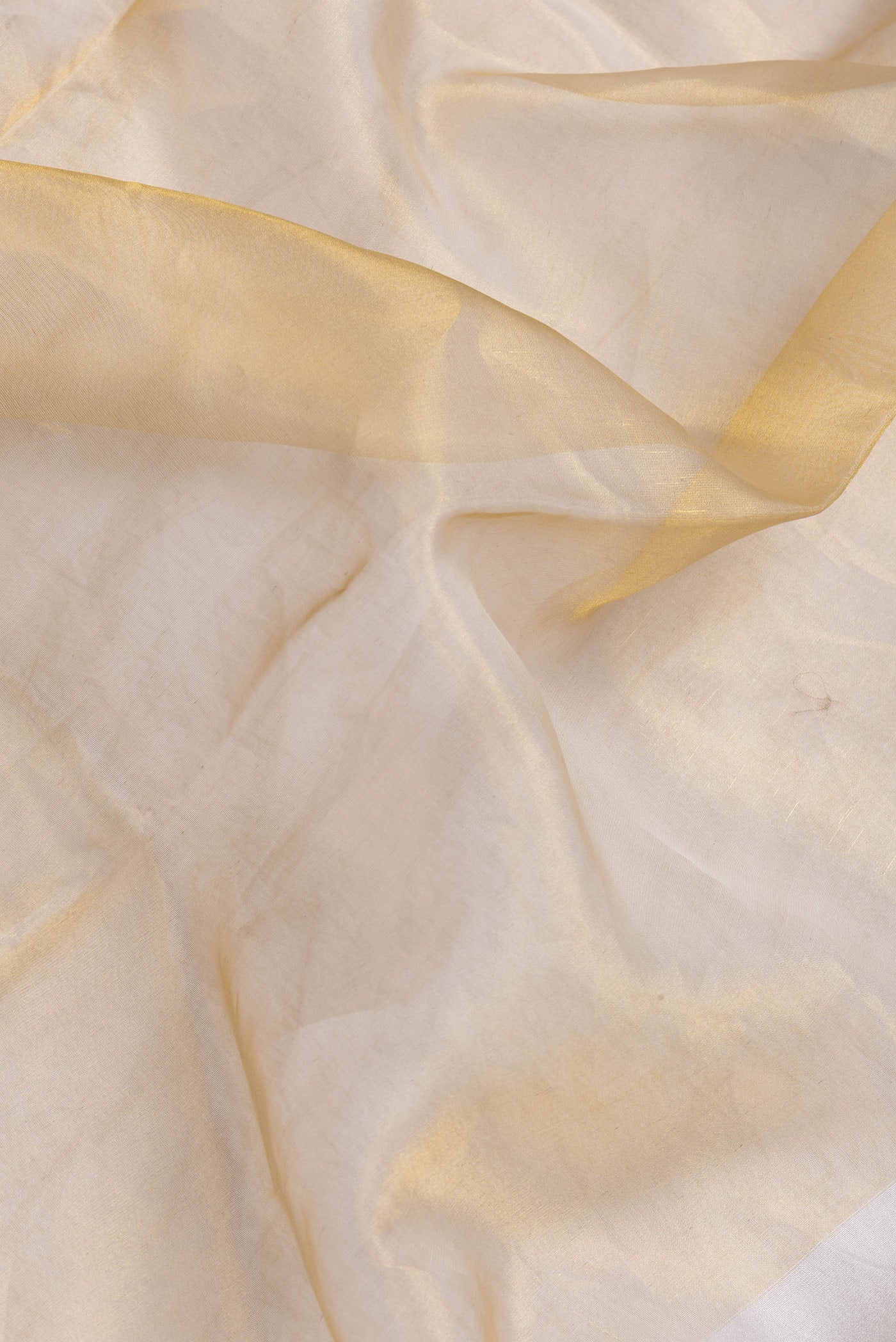 Close up of Gold Dual Tone Organza Silk Saree with Plain Body and Plain Border.  displaying folds