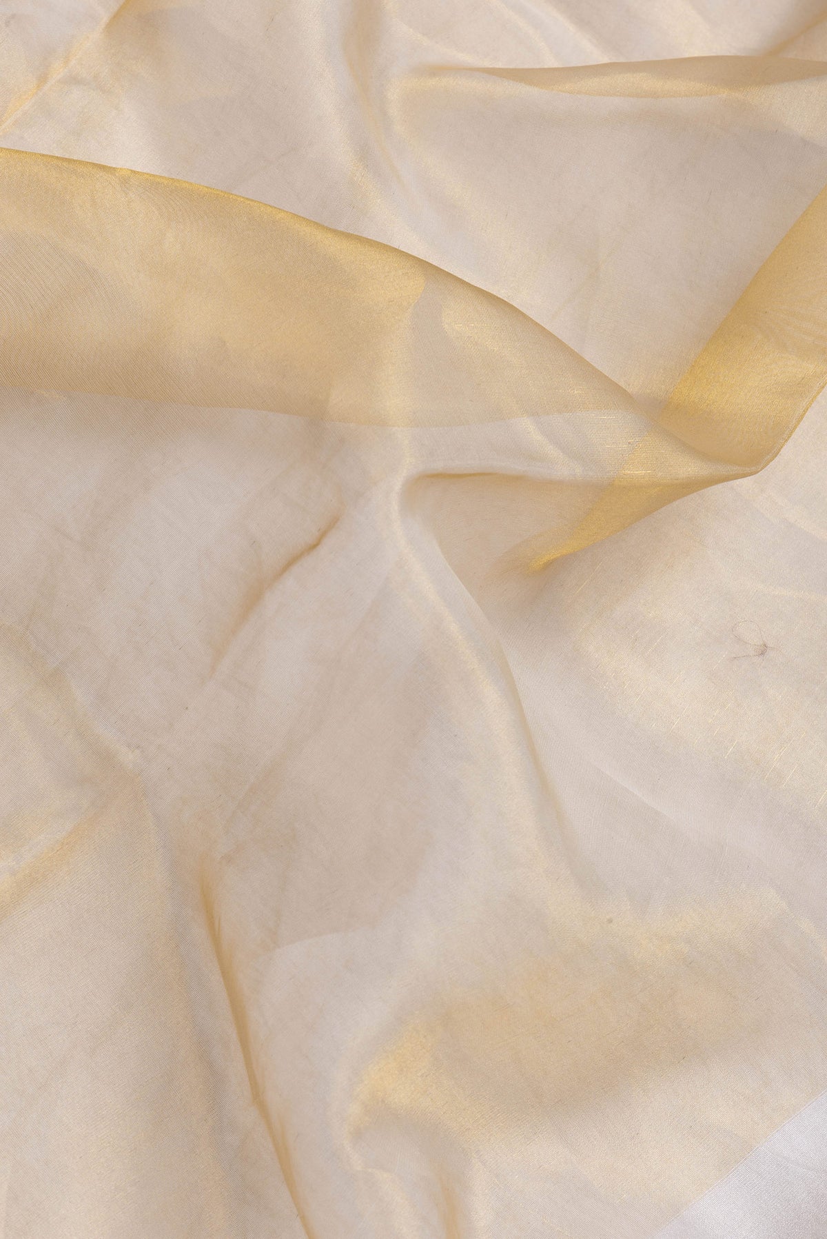 Close up of Gold Dual Tone Organza Silk Saree with Plain Body and Plain Border.  displaying folds