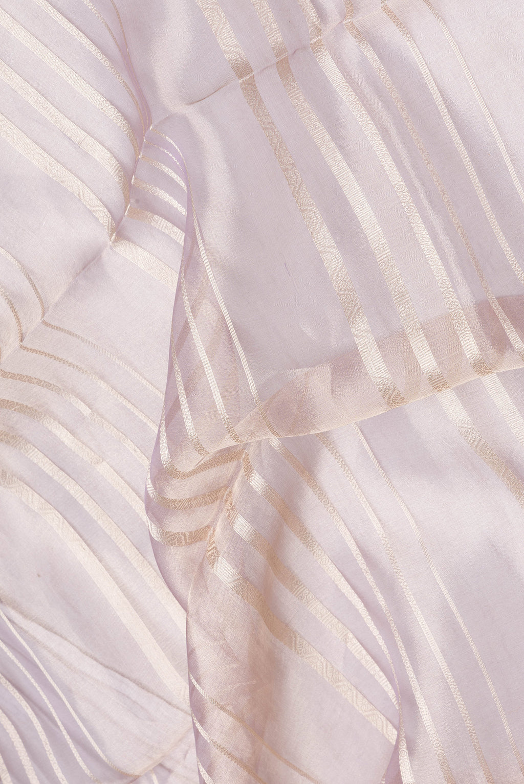 Close up of Rose Gold Dual Tone Organza Silk Saree with Stripes on the body and Zari Border.  displaying folds