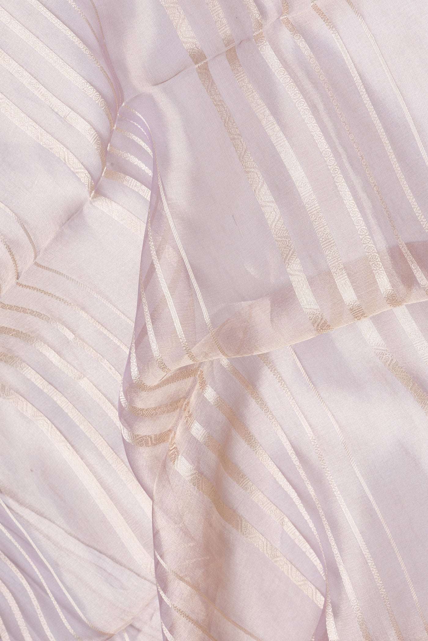 Close up of Rose Gold Dual Tone Organza Silk Saree with Stripes on the body and Zari Border.  displaying folds