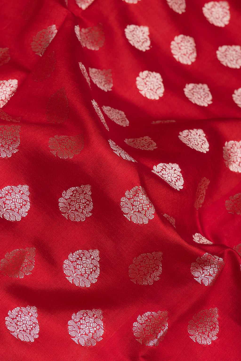 Close up of Red Dual Tone Tussar Silk Saree with Zari Butta on the body and Zari Border.  displaying folds