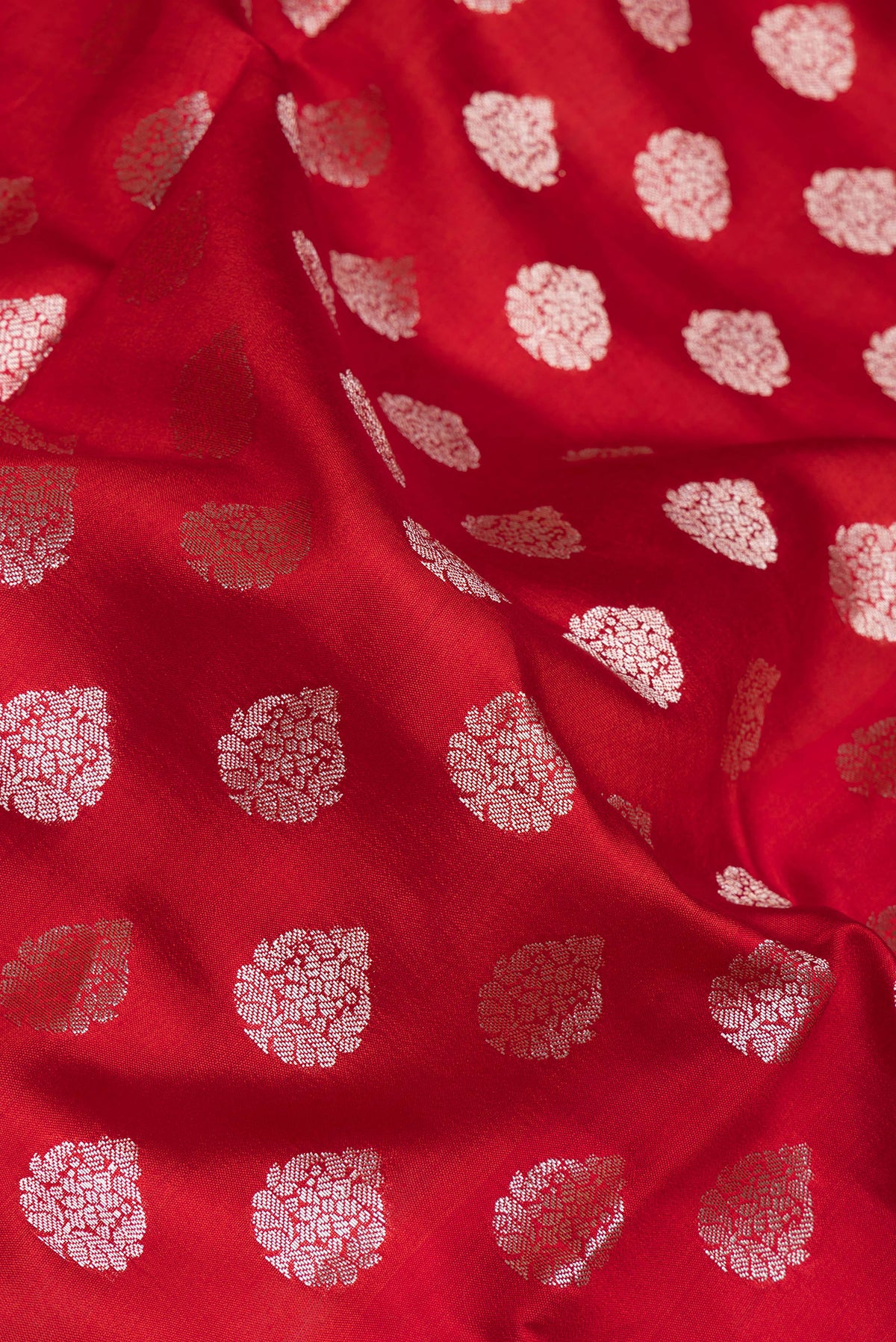 Close up of Red Dual Tone Tussar Silk Saree with Zari Butta on the body and Zari Border.  displaying folds