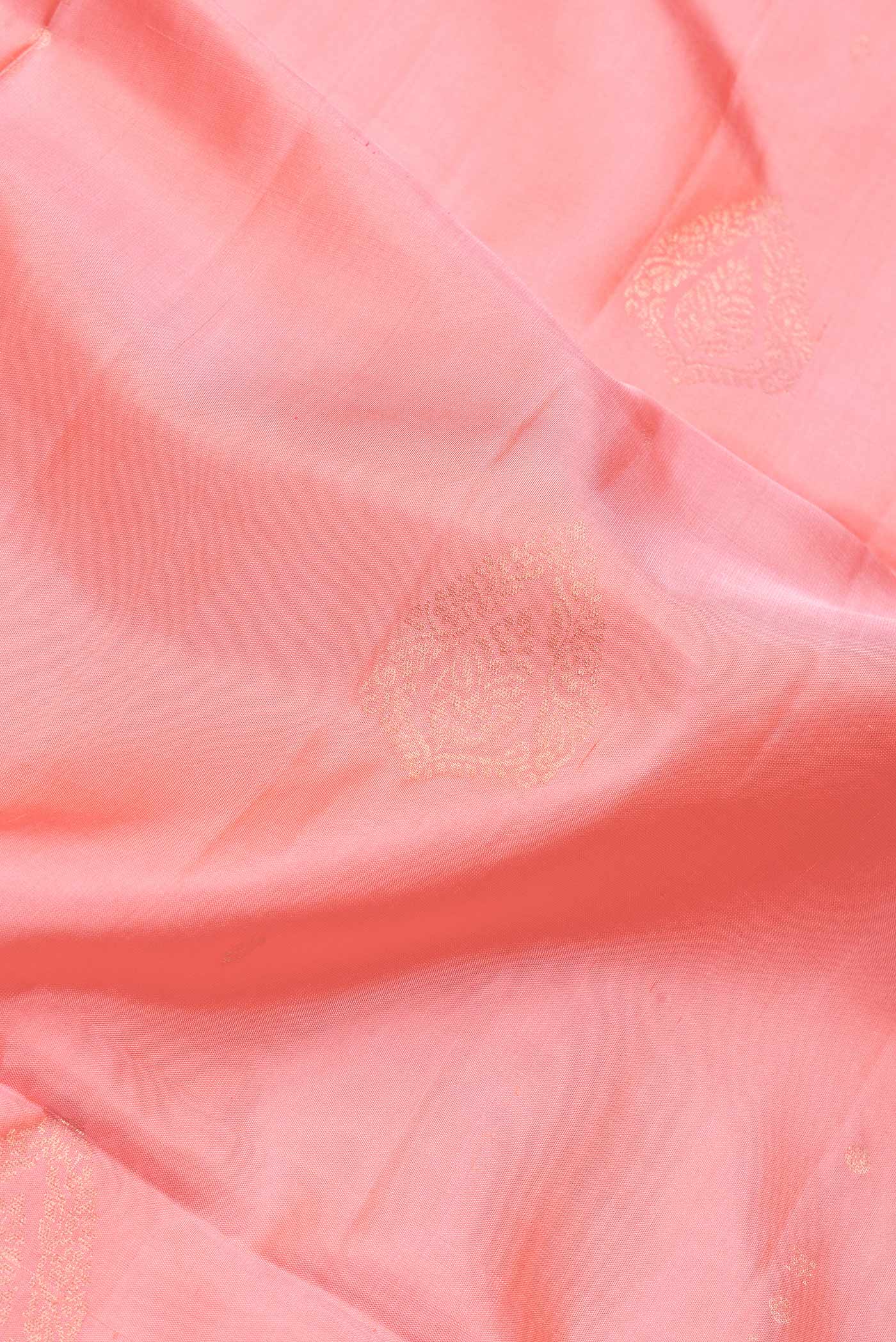 Close up of Peach Dual Tone Soft Silk Saree with Zari Butta on the body and Zari Border.  displaying folds