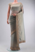 Green Tissue Silk Saree with Plain Body and Embroidery Border displayed on a mannequin