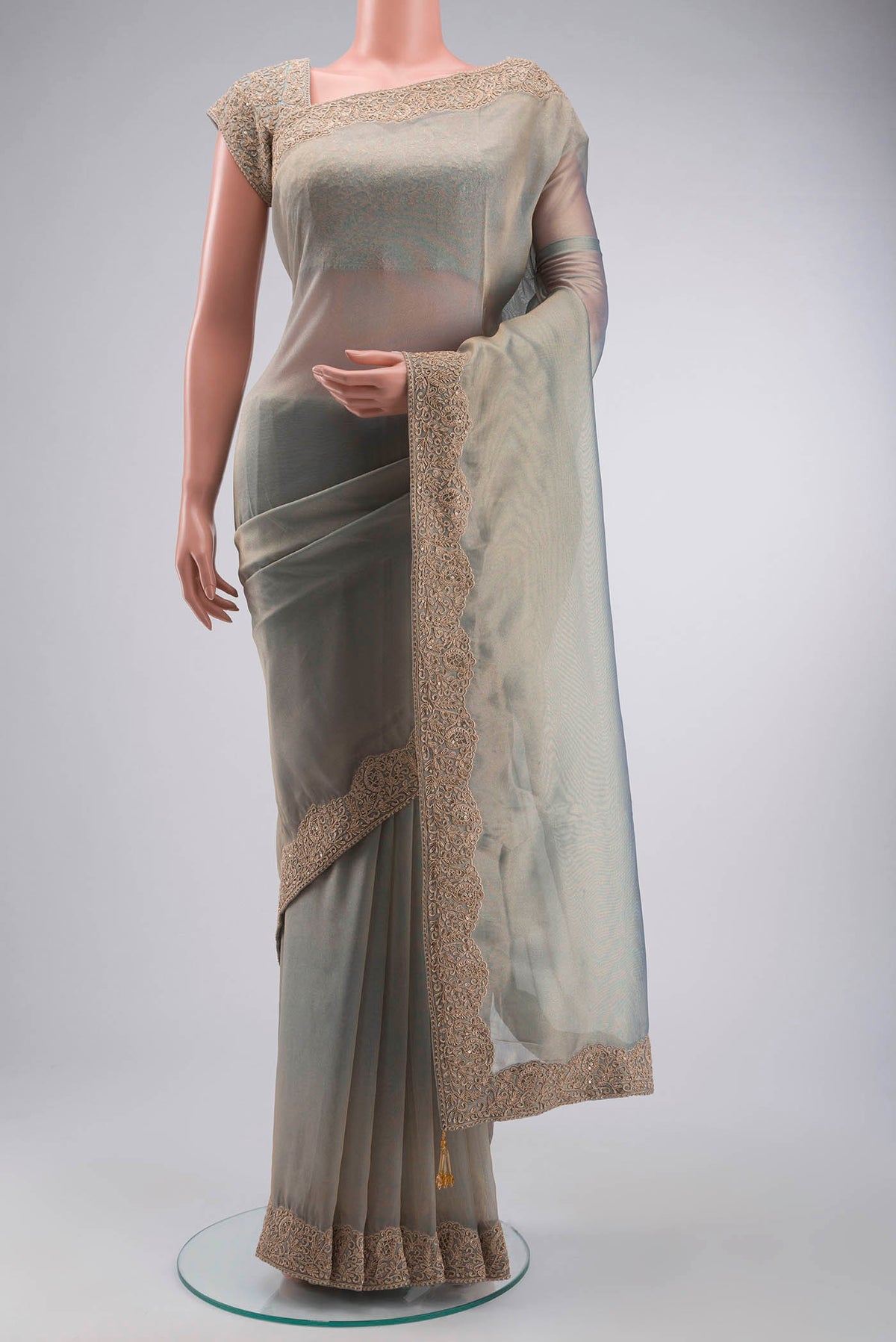 Green Tissue Silk Saree with Plain Body and Embroidery Border displayed on a mannequin