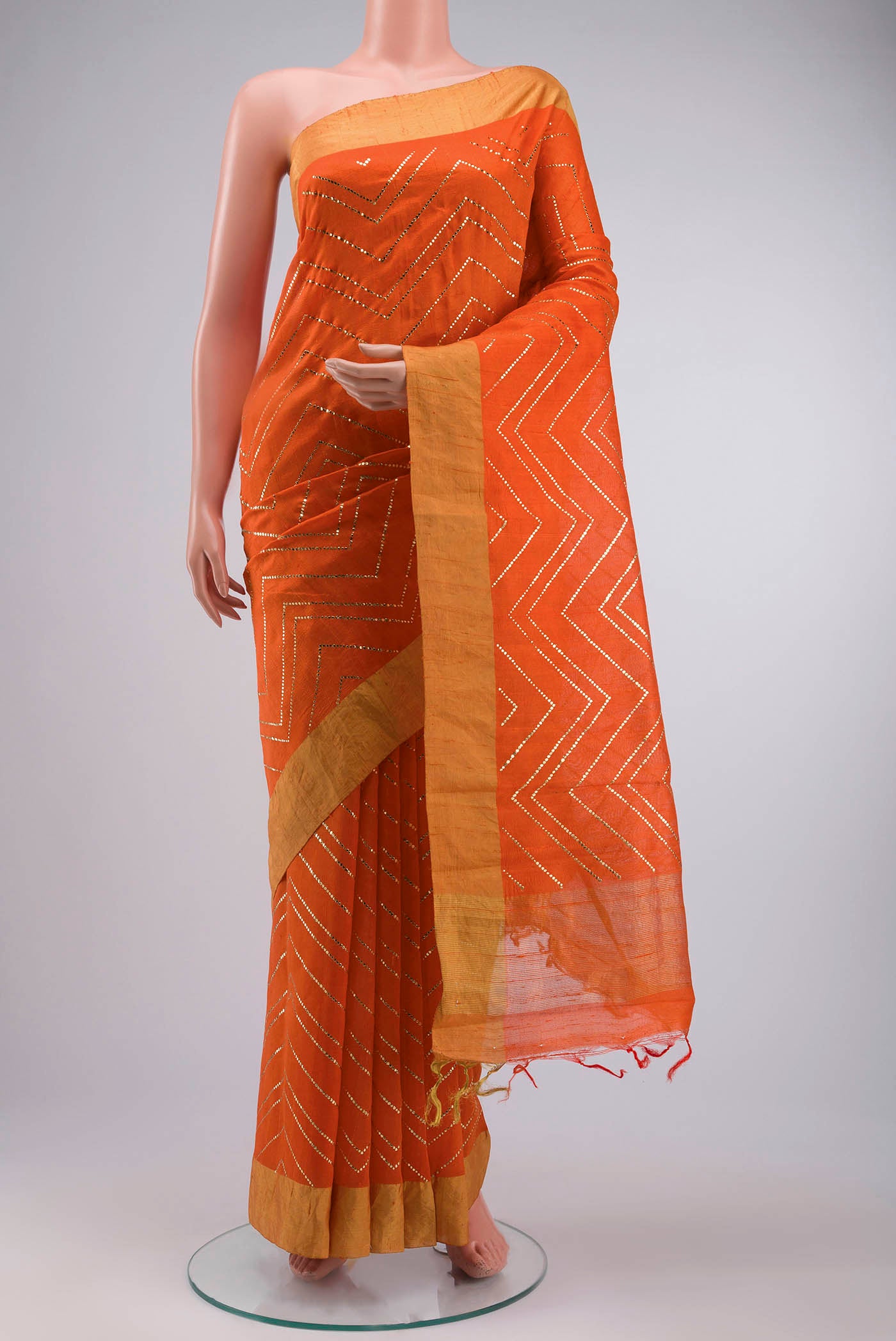 Orange Raw Silk Saree with Embroidery on the body and Zari Border displayed on a mannequin