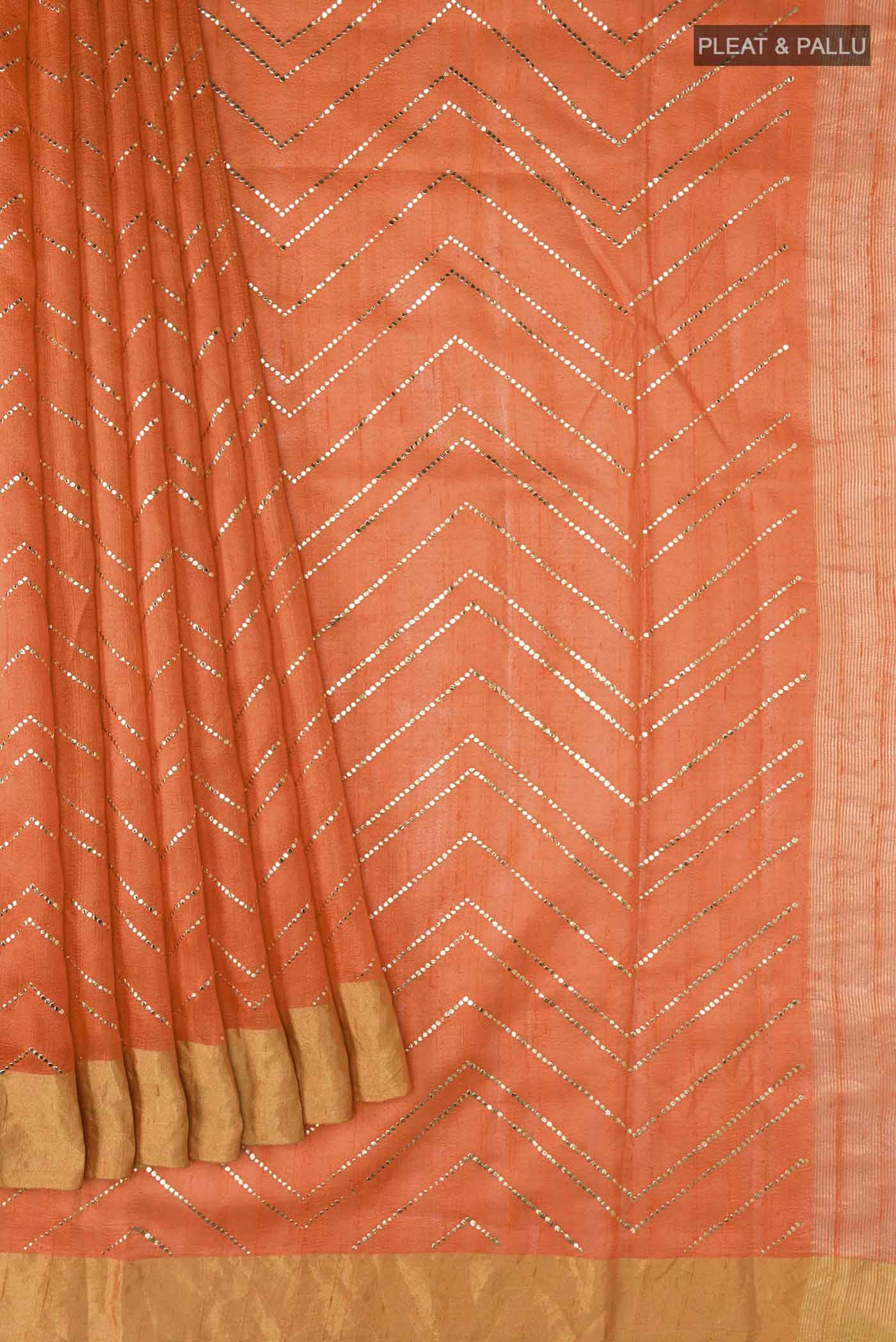 Pleats and pallu of Orange Raw Silk Saree with Embroidery on the body and Zari Border