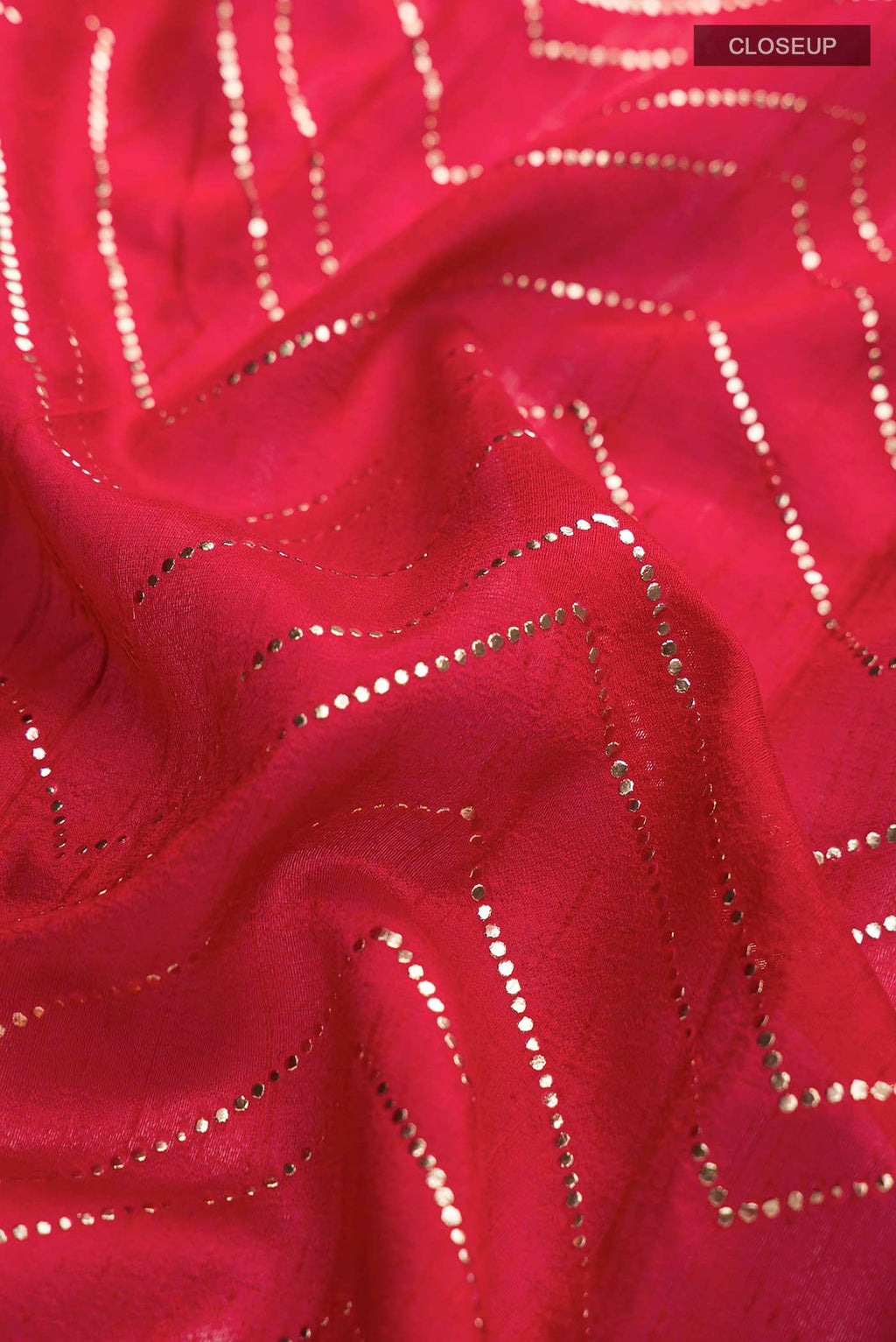 Close up of Red Raw Silk Saree with Embroidery on the body and Zari Border displaying folds