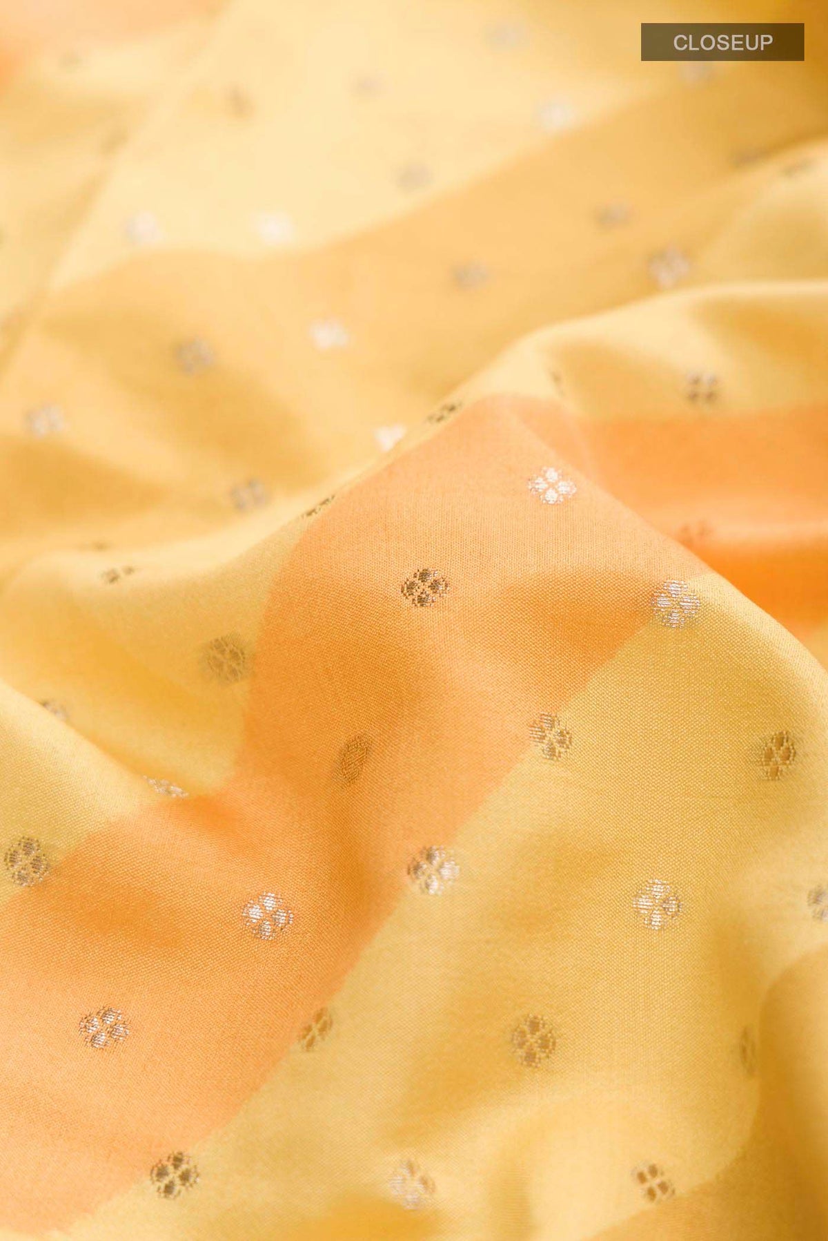 Close up of Multi Color Banarasi Raw Silk Saree with Zari Butta on the body and Zari Border displaying folds