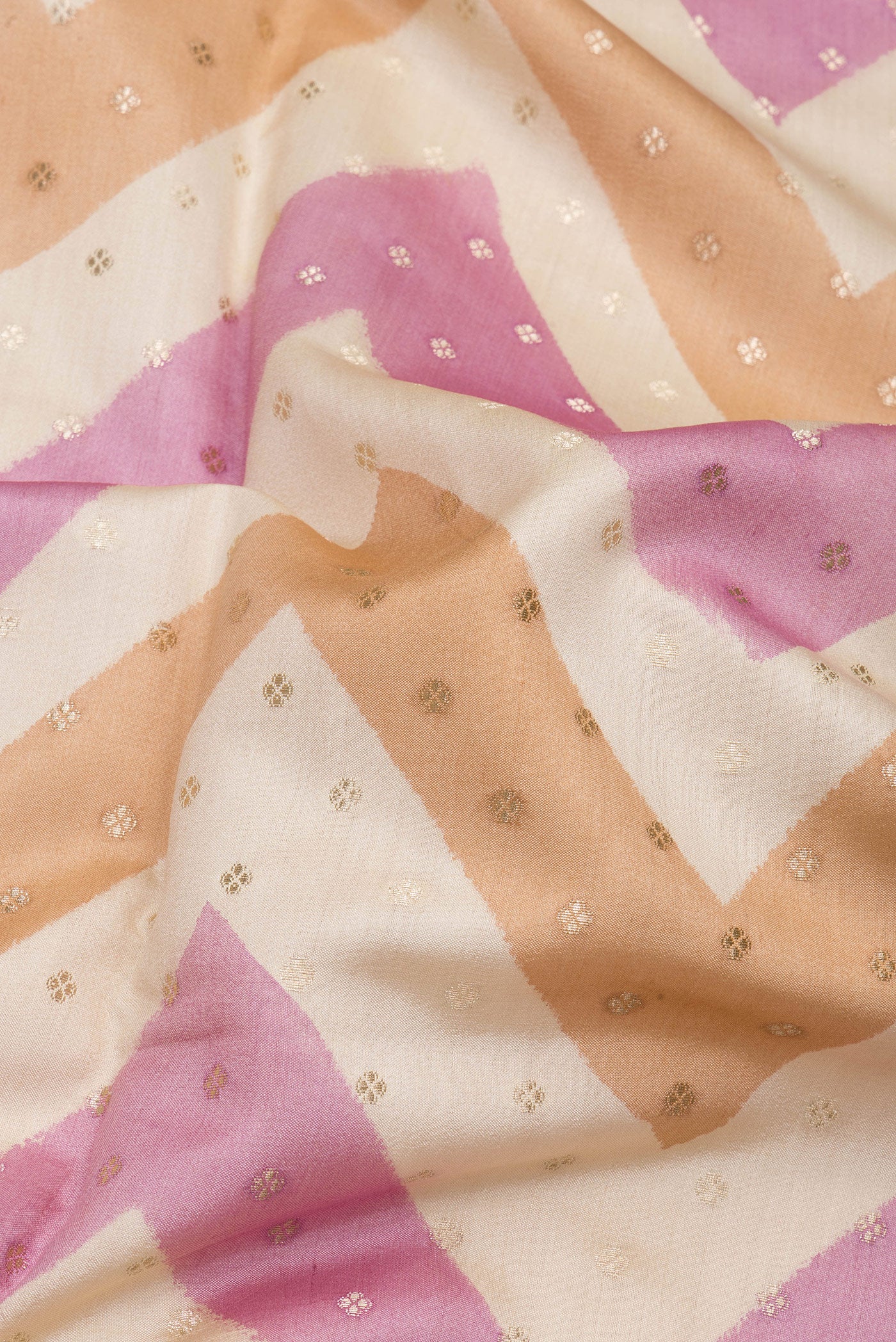 Close up of Beige Dual Tone Tussar Silk Saree with Zari Butta on the body and Zari Border.  displaying folds