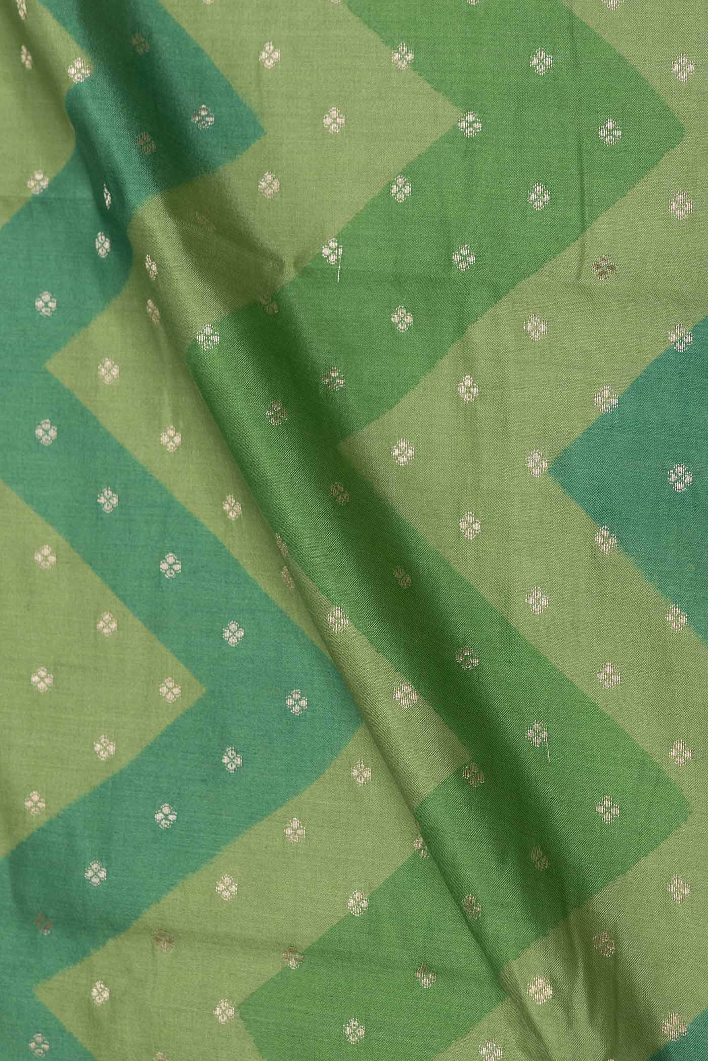 Close up of Green Dual Tone Tussar Silk Saree with Zari Butta on the body and Zari Border displaying folds