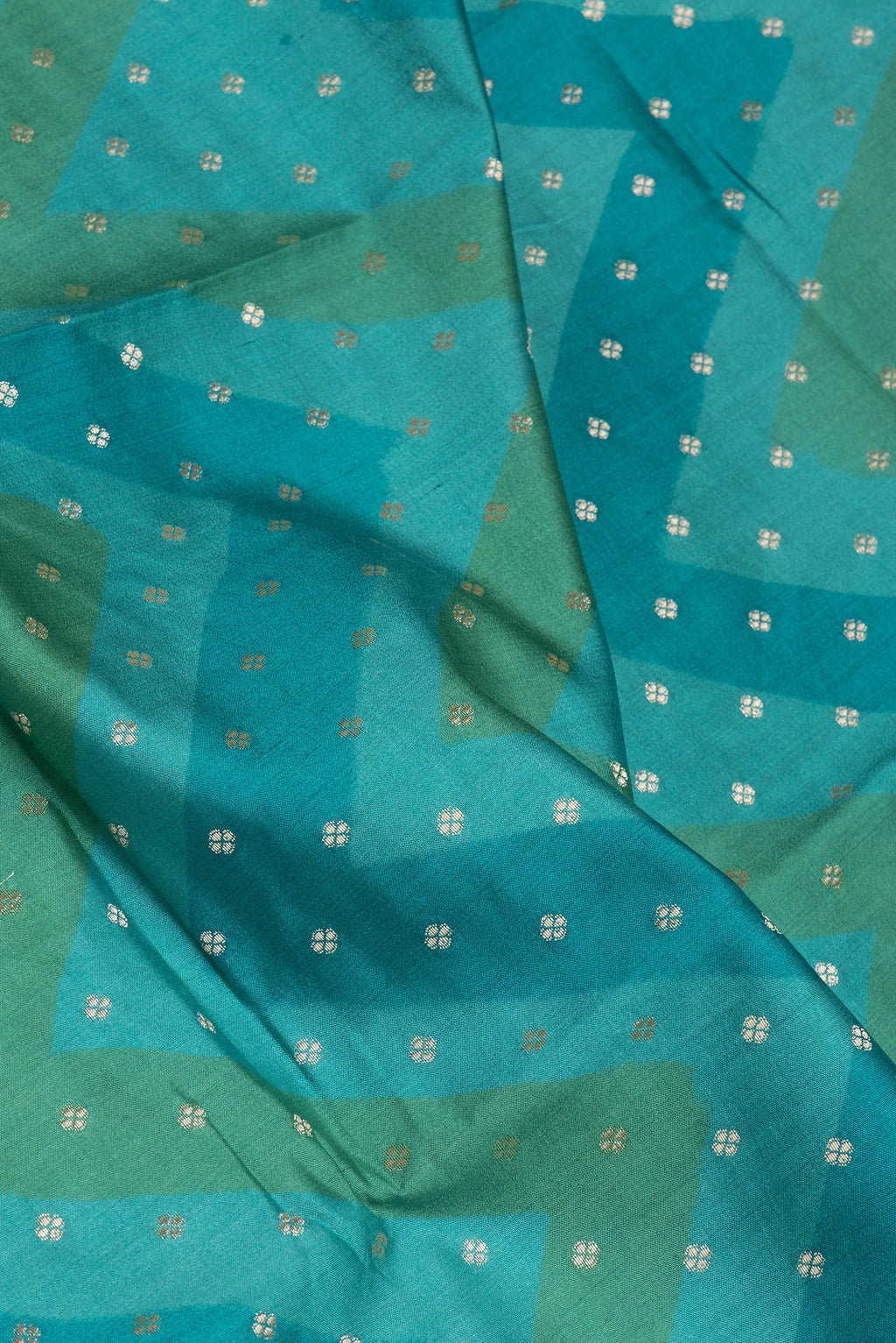 Close up of Peacock Blue Tussar Silk Saree with Zari Butta on the body and Zari Border.  displaying folds