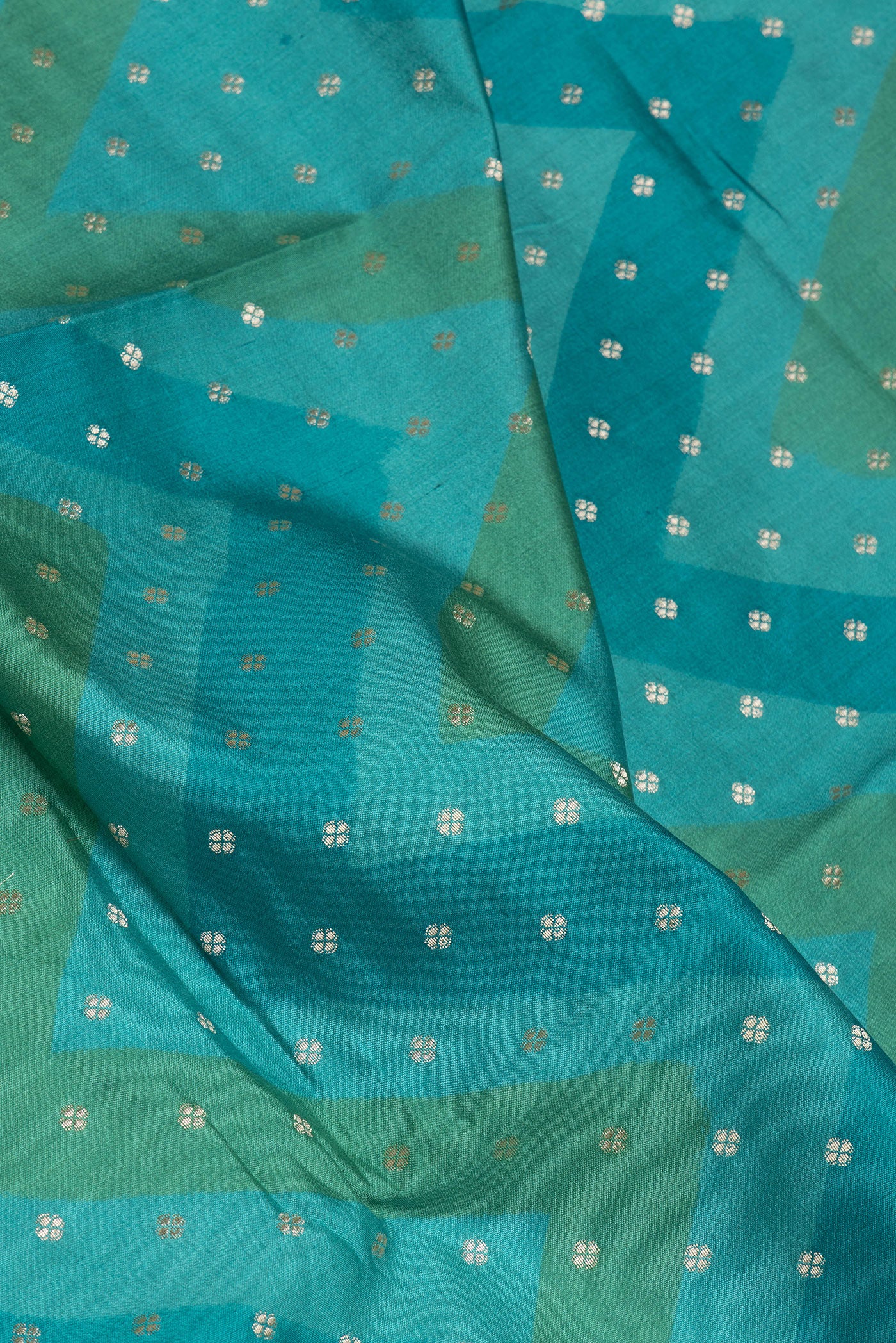Close up of Peacock Blue Tussar Silk Saree with Zari Butta on the body and Zari Border.  displaying folds