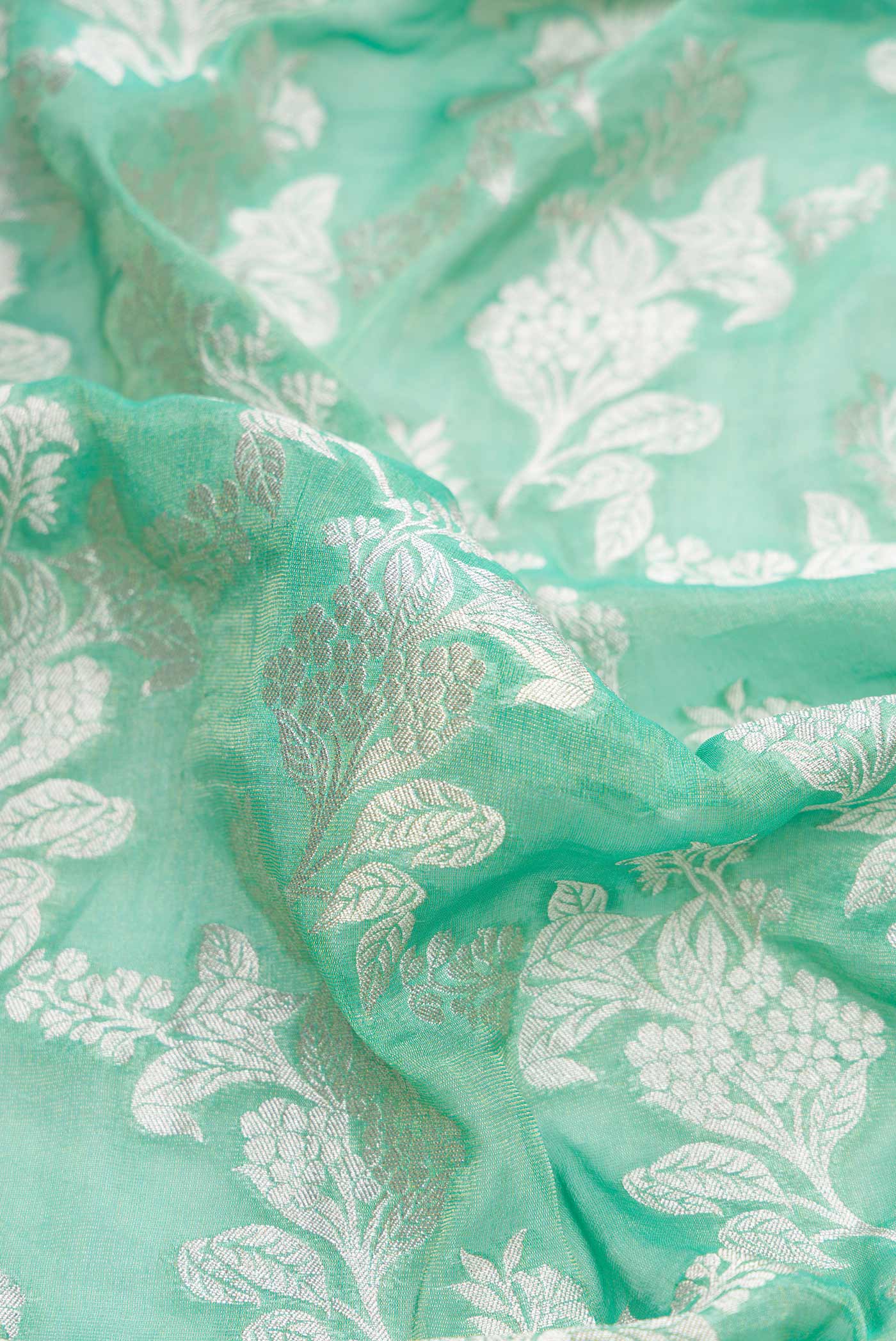 Close up of Green Dual Tone Banarasi Georgette Saree with Zari Brocade on the body and Zari Border.  displaying folds