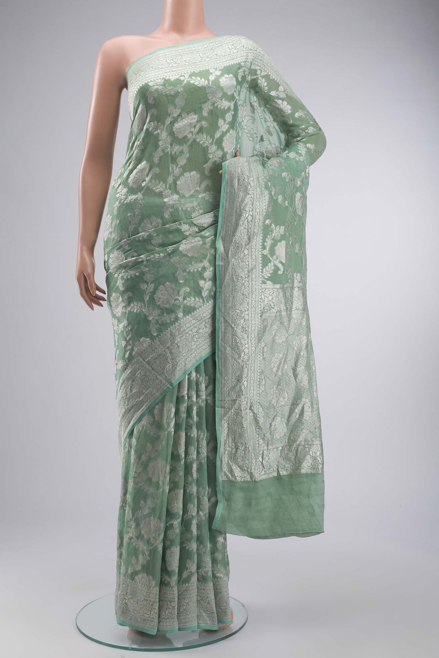 Green Banarasi Georgette Saree with Zari Butta on the body and Zari Border displayed on a mannequin