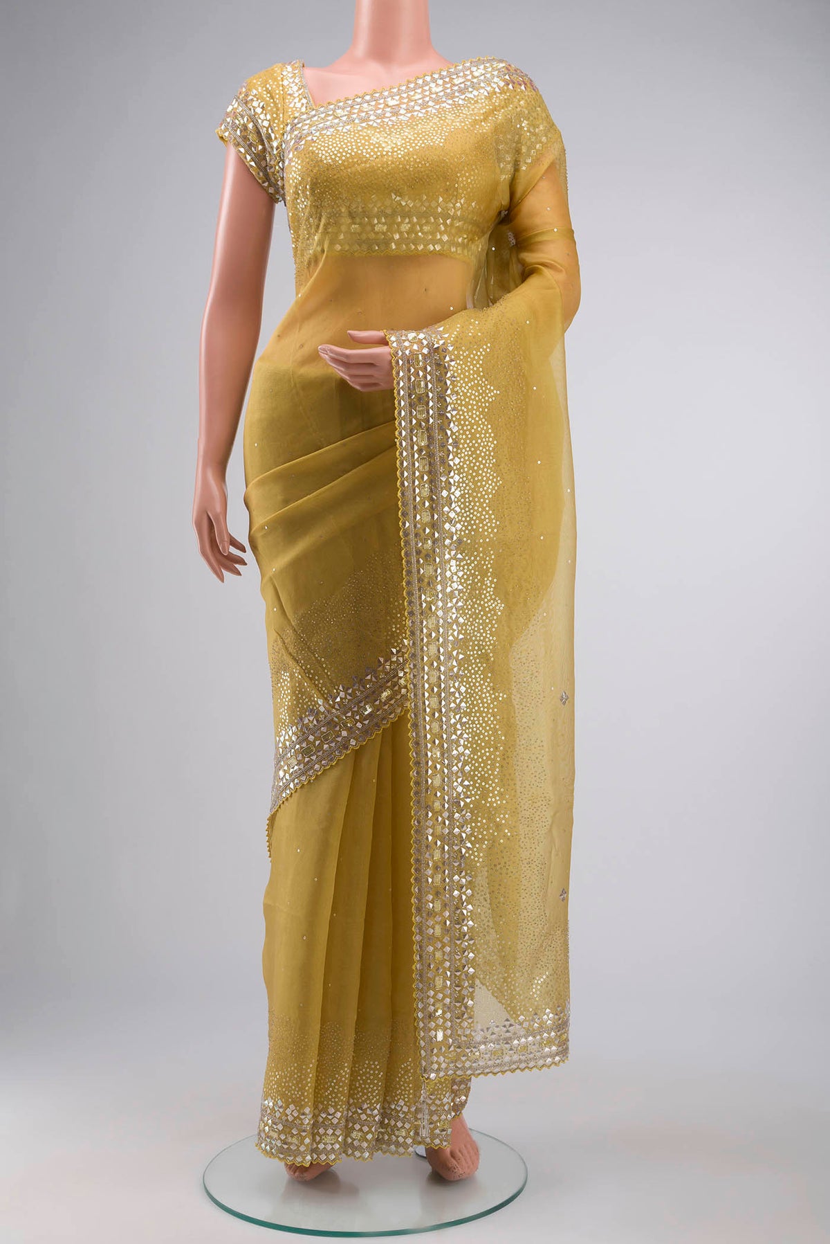 Yellow Organza Silk Saree with Embroidery on the body and Embroidery Border displayed on a mannequin