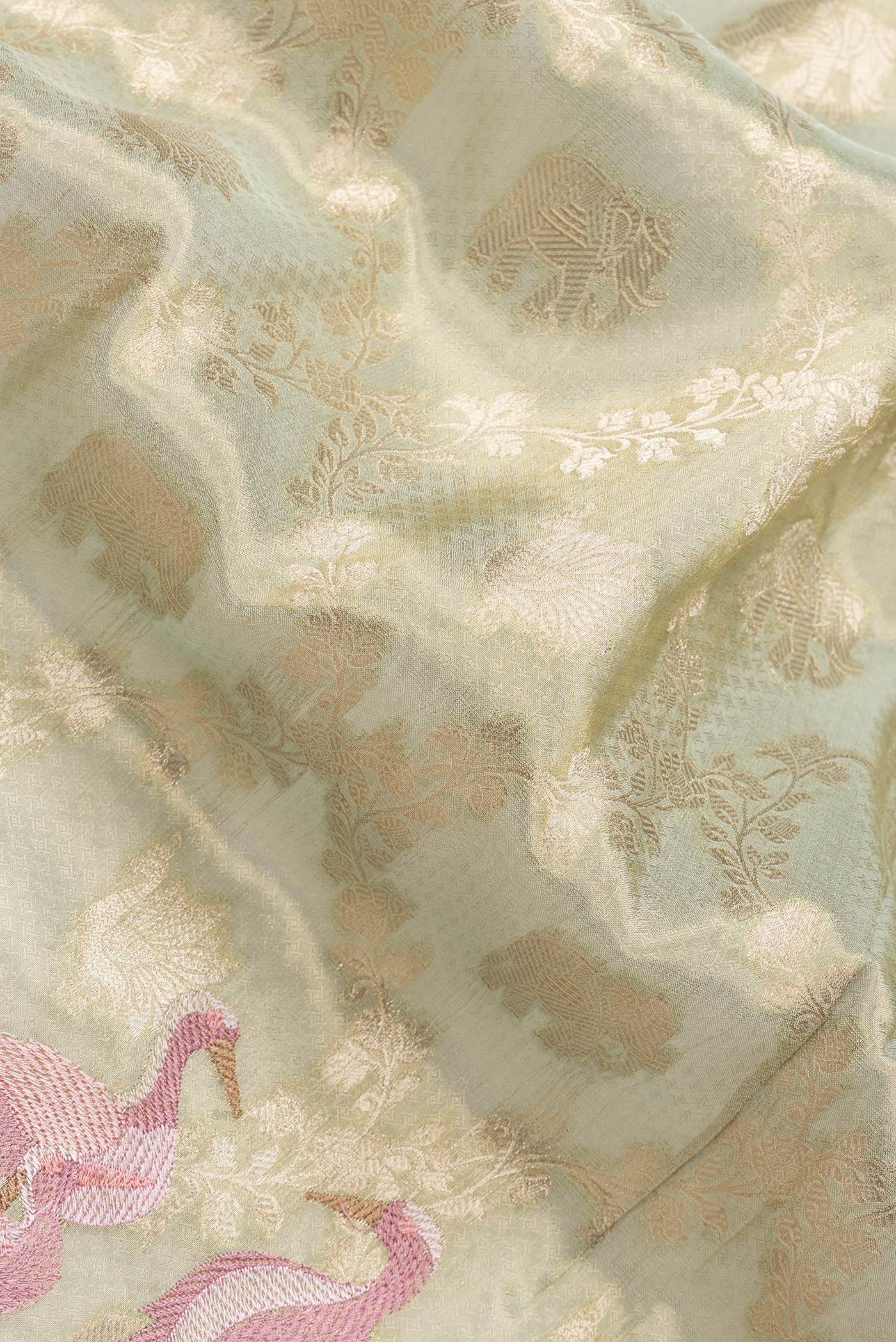 Close up of Pista Green Dual Tone Organza Silk Saree with Zari Brocade on the body and Embroidery Border.  displaying folds