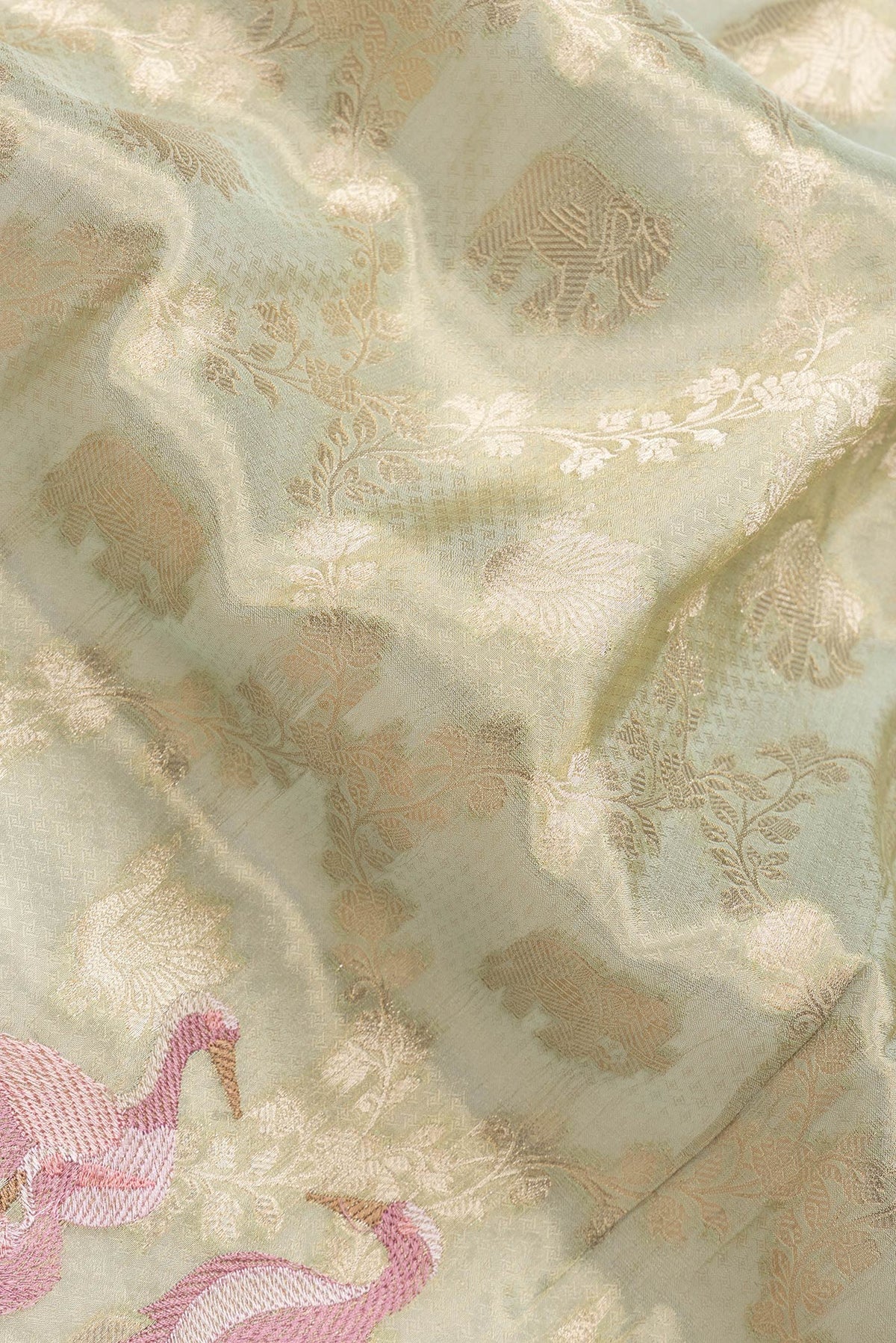 Close up of Pista Green Dual Tone Organza Silk Saree with Zari Brocade on the body and Embroidery Border.  displaying folds