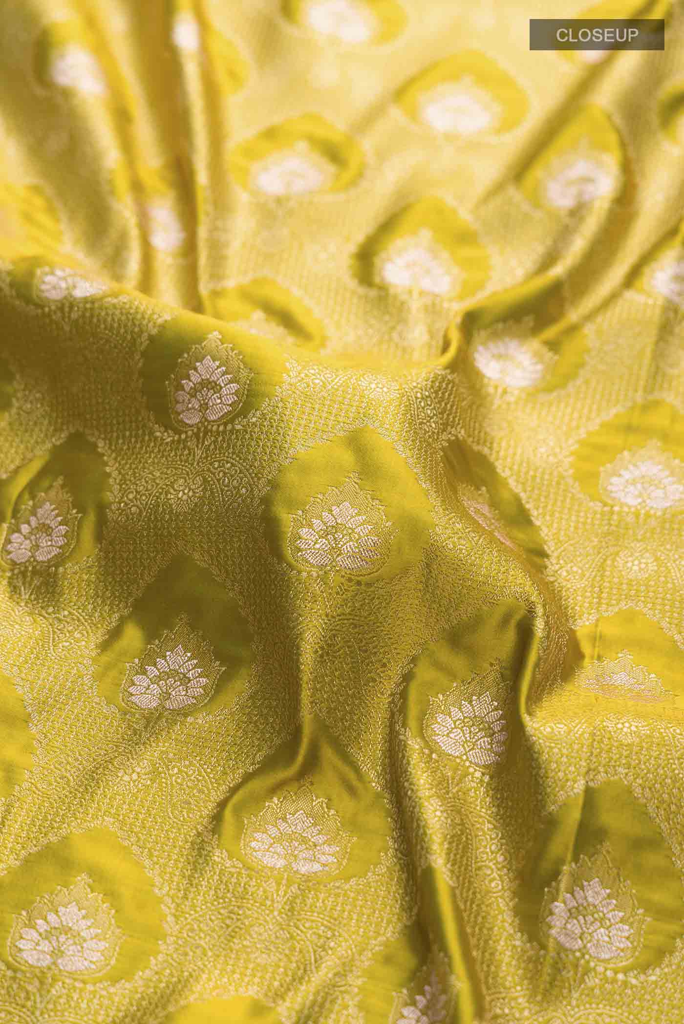 Close up of Green Blended Banarasi Silk Saree with Zari Butta on the body and Zari Border displaying folds