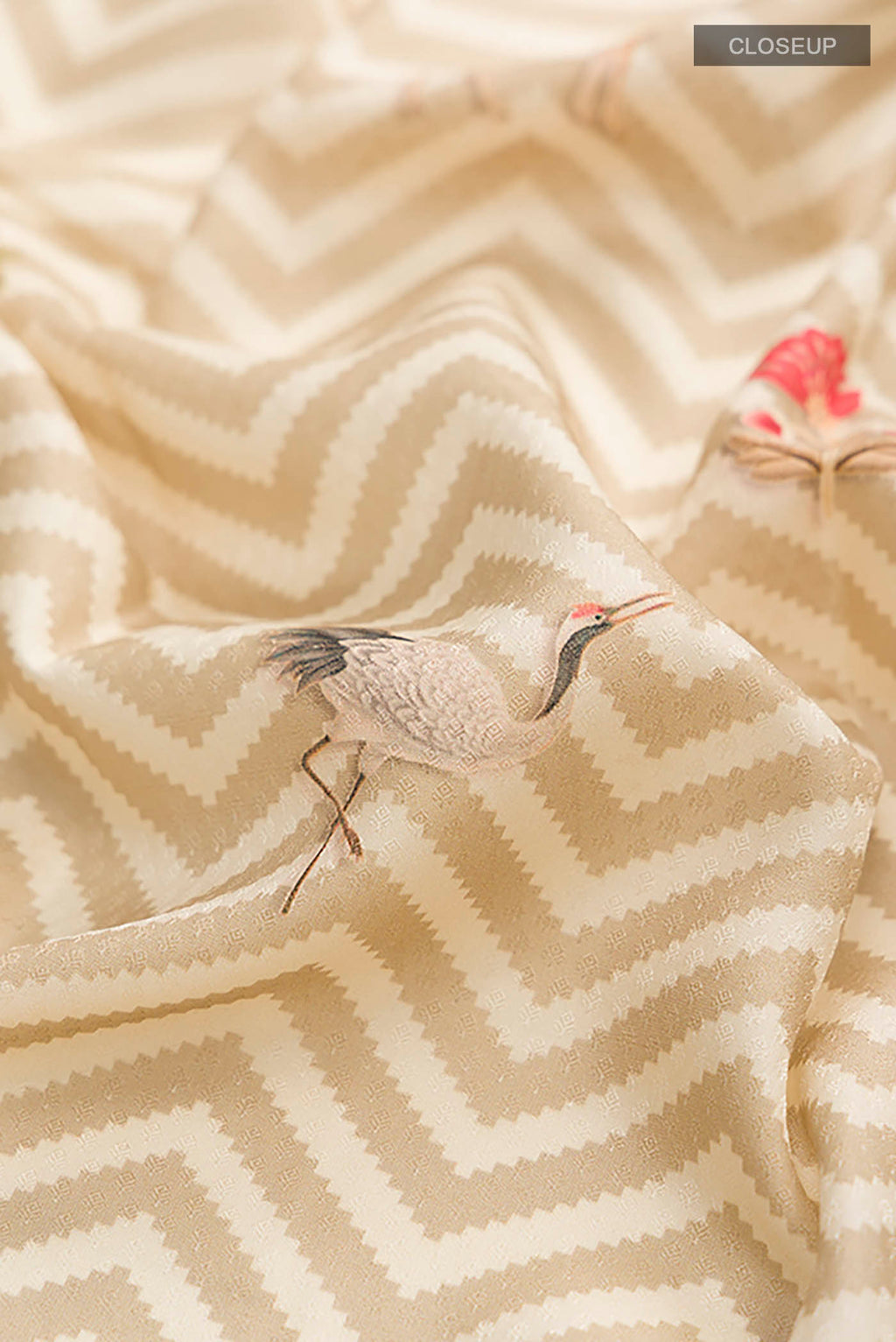 Close up of Beige Printed Silk Saree with Printed design on the body and Zari Border displaying folds