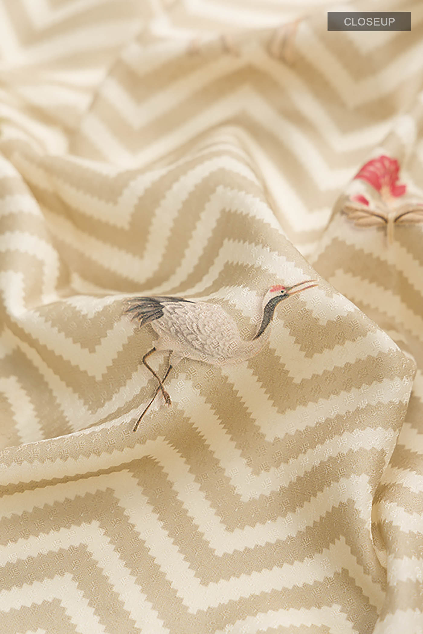 Close up of Beige Printed Silk Saree with Printed design on the body and Zari Border displaying folds