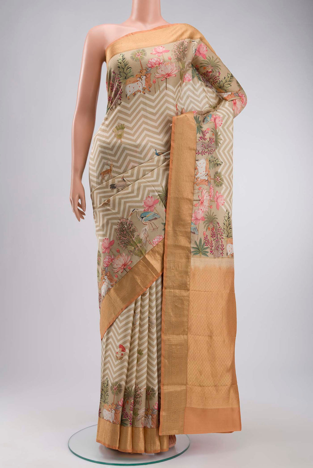 Beige Printed Silk Saree with Printed design on the body and Zari Border displayed on a mannequin