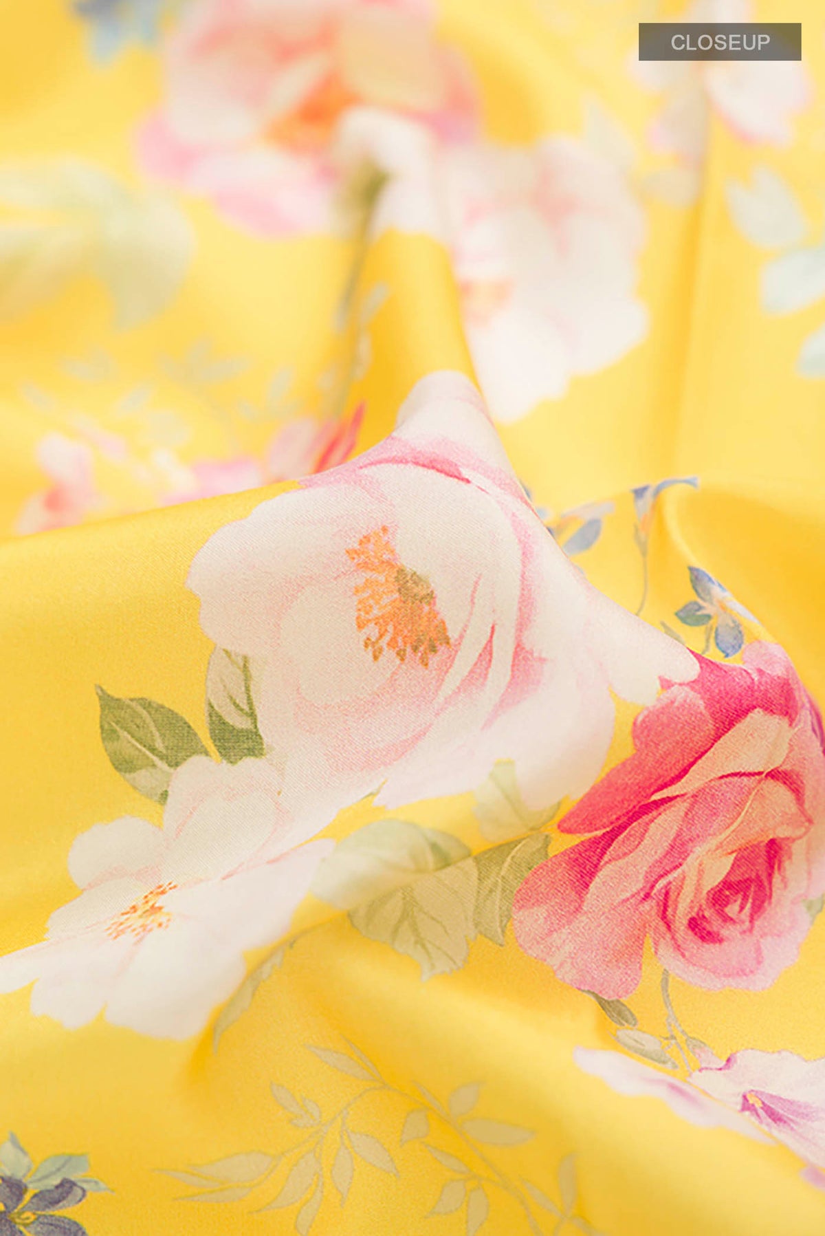 Close up of Yellow Printed Silk Saree with Printed design on the body and Zari Border displaying folds