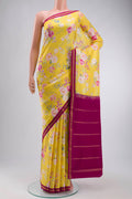 Yellow Printed Silk Saree with Printed design on the body and Zari Border displayed on a mannequin
