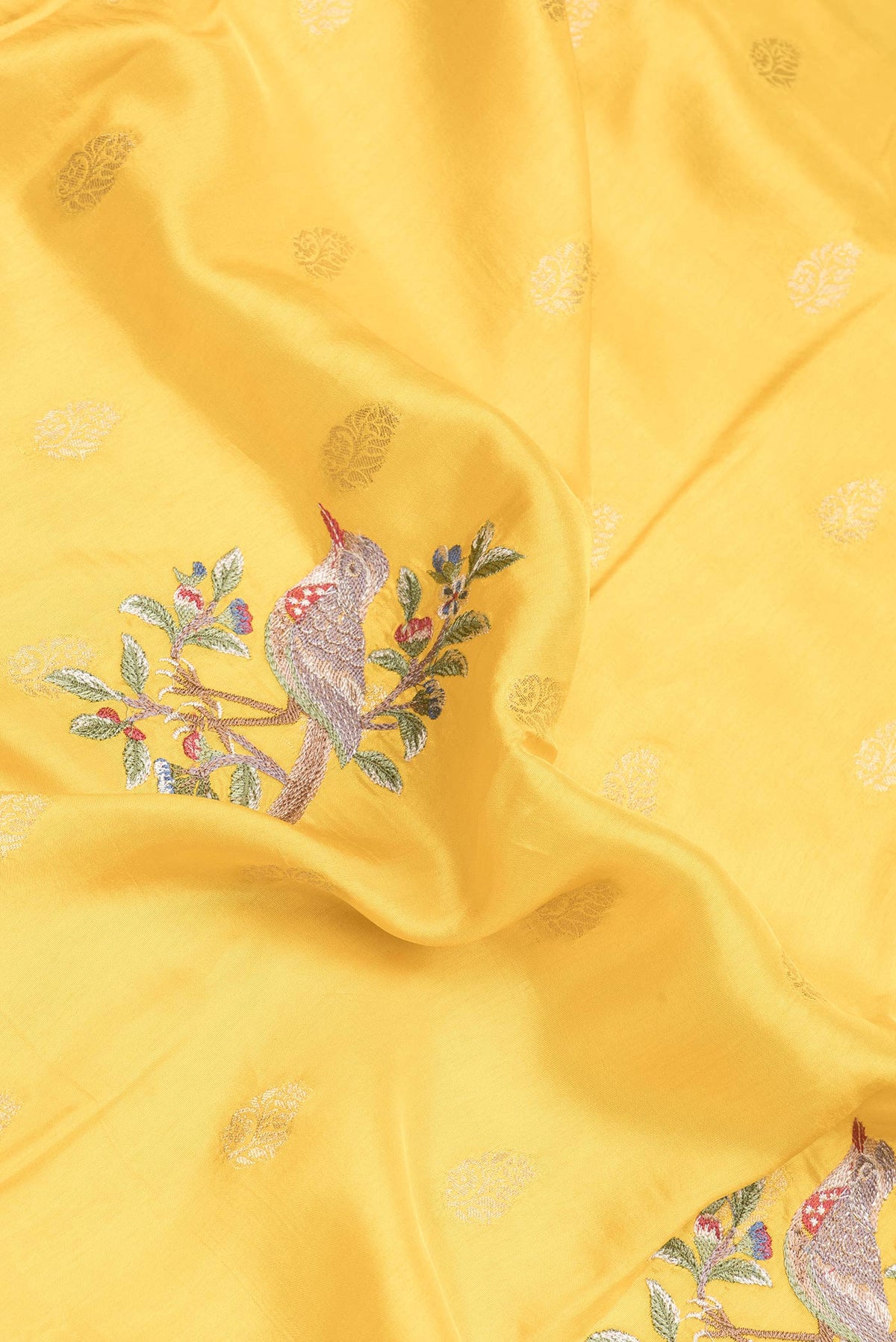 Close up of Yellow Dual Tone Tussar Silk Saree with Zari Butta on the body and Fancy Border.  displaying folds
