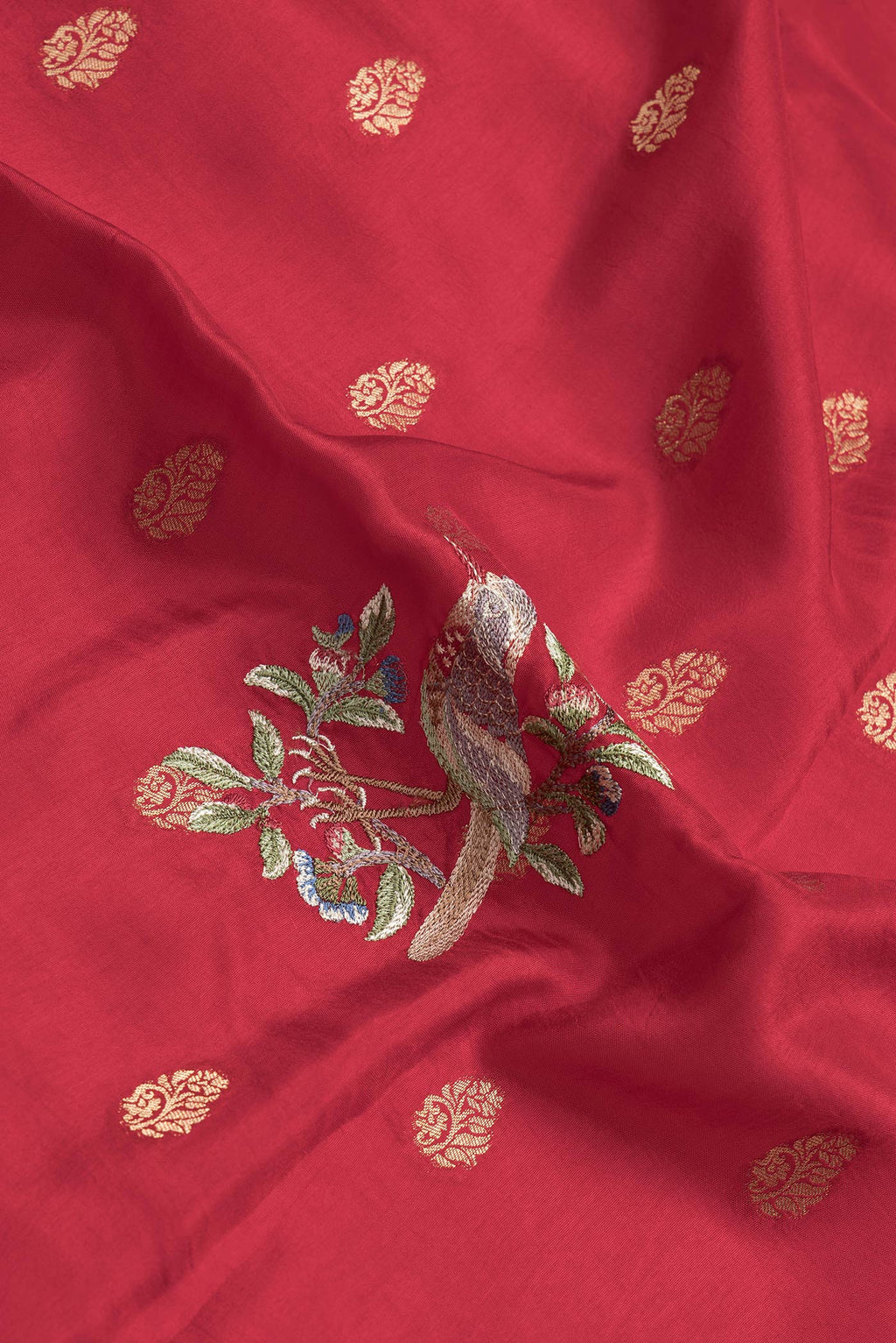 Close up of Red Dual Tone Tussar Silk Saree with Zari Butta on the body and Fancy Border.  displaying folds