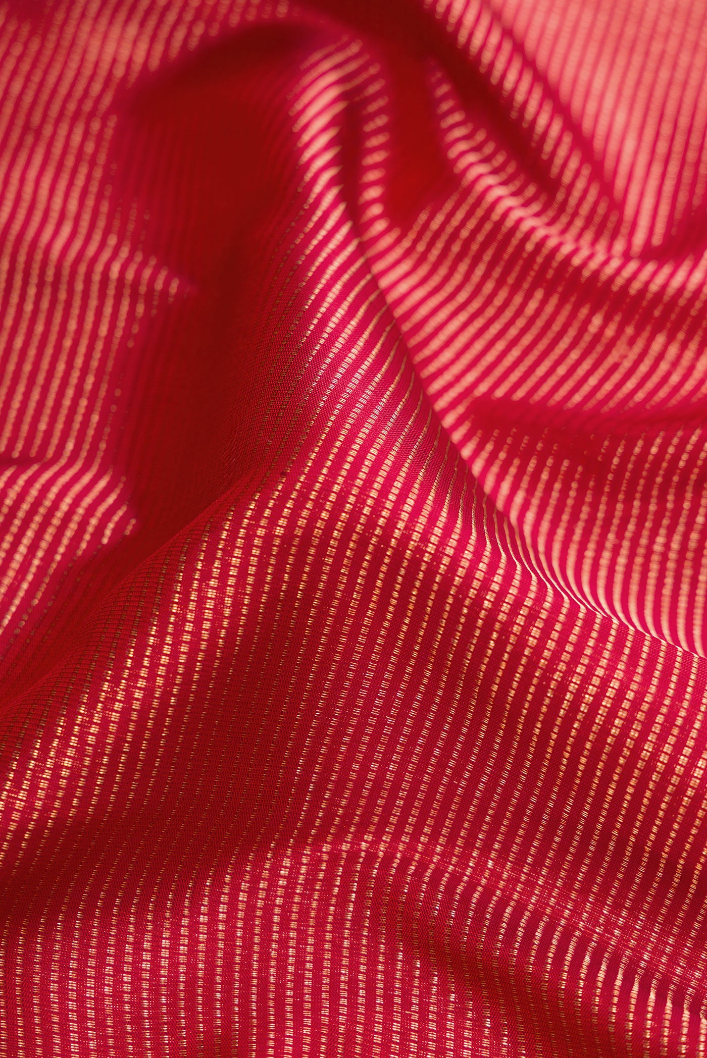 Close up of Red Dual Tone Kanjivaram Silk Saree with Zari Brocade on the body and Zari Border.  displaying folds