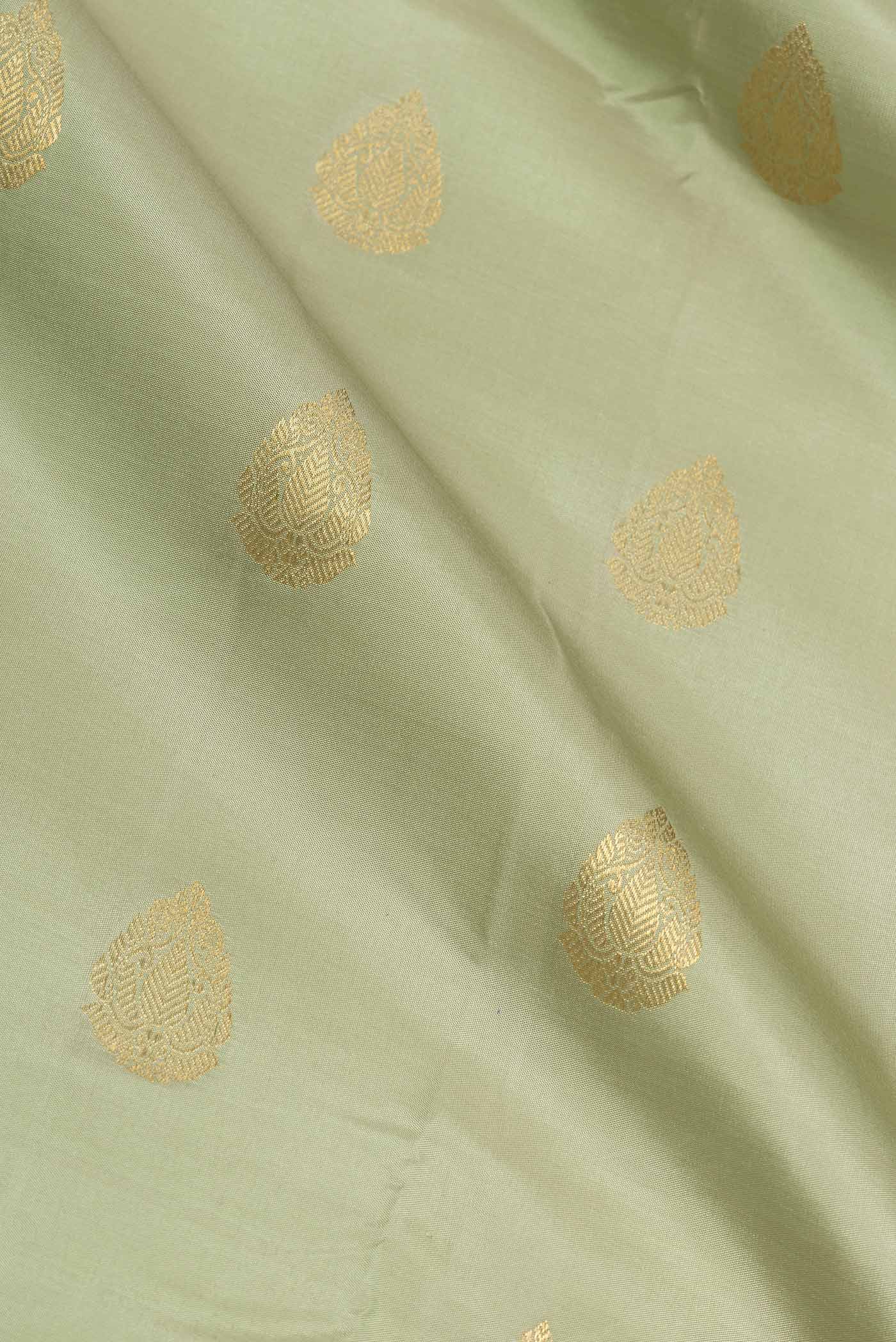 Close up of Pista Green Dual Tone Kanchipuram Saree with Zari Butta on the body and Zari Border displaying folds