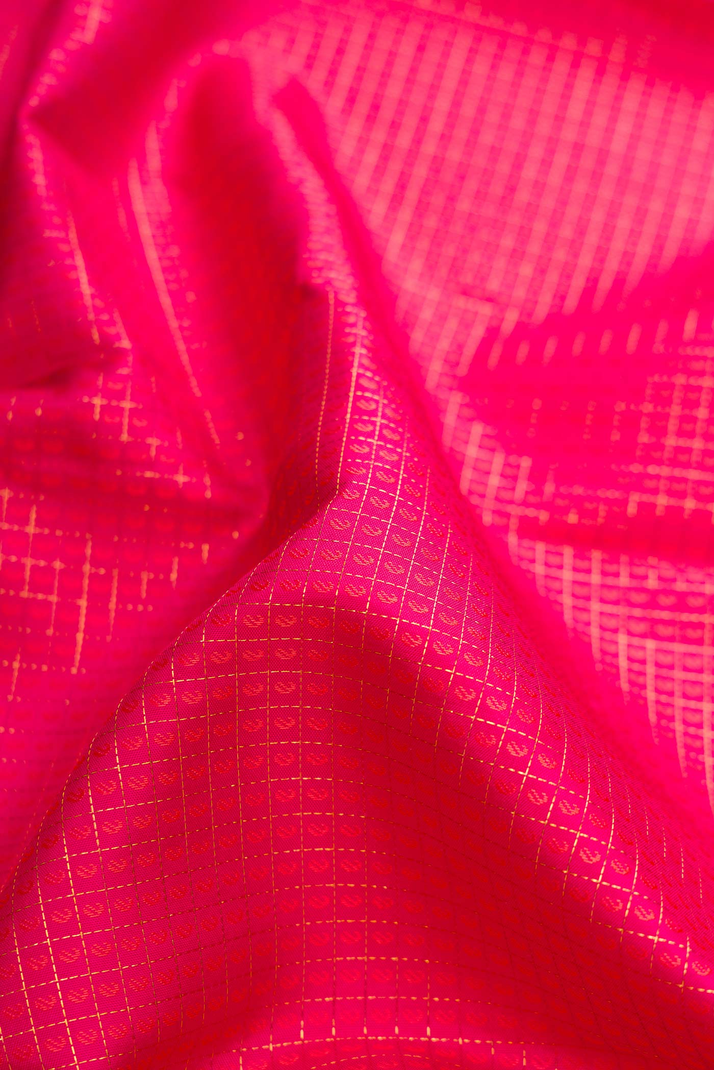 Close up of Dark Pink Dual Tone Kanjivaram Silk Saree with Jacquard design on the body and Zari Border.  displaying folds