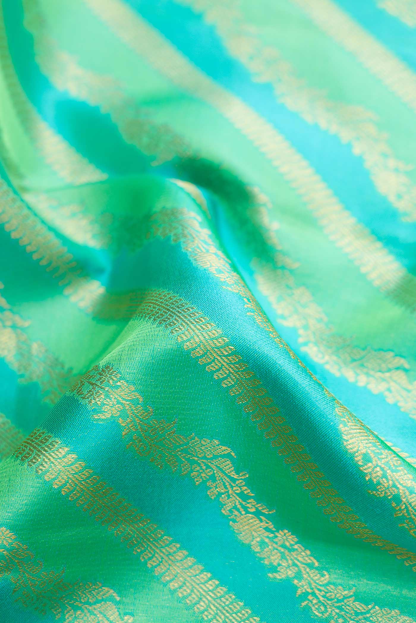 Close up of Pista Green and Sky Blue Dual Tone Kanjivaram Silk Saree with Zari Brocade on the body and Zari Border.  displaying folds