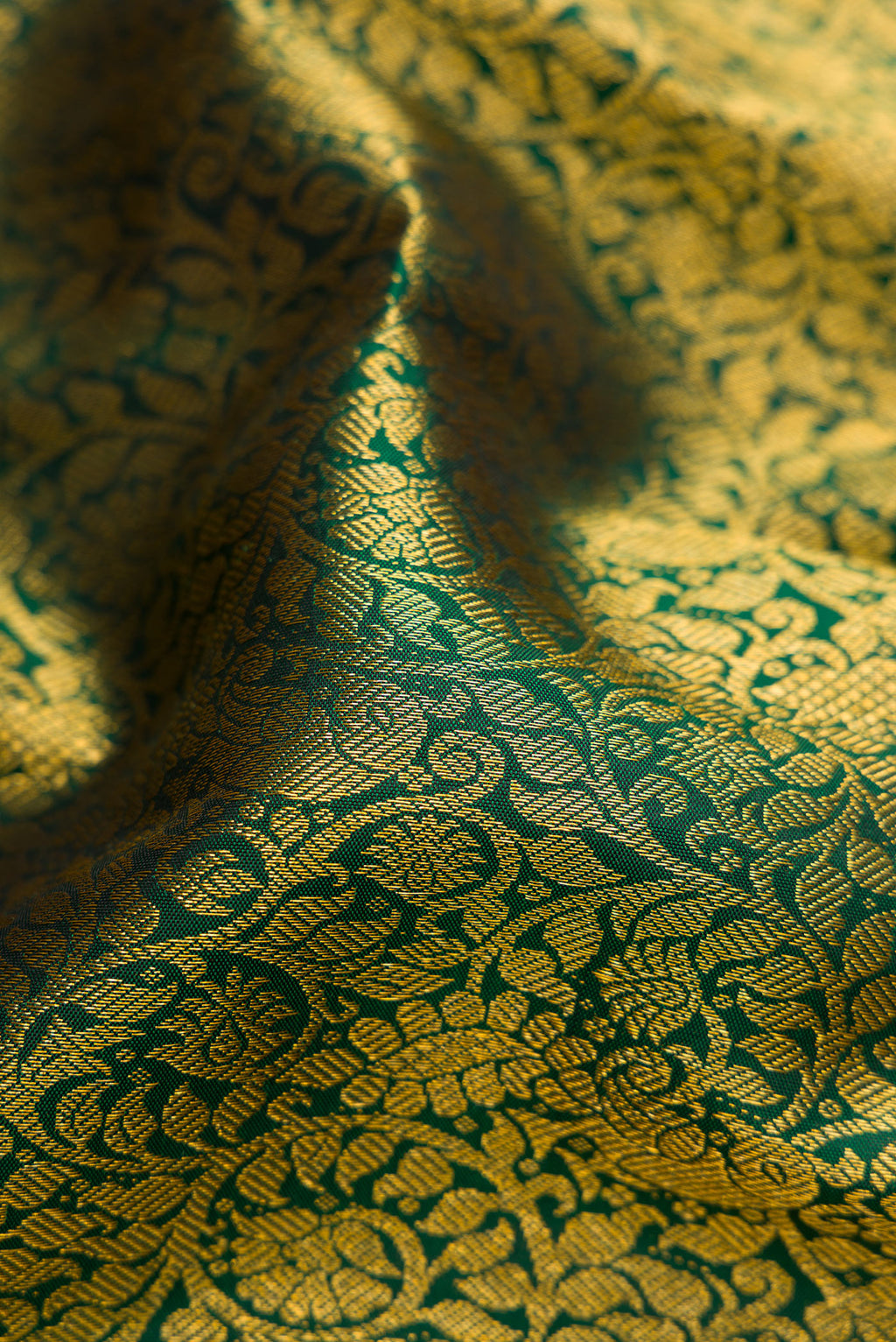 Close up of Bottle Green Dual Tone Kanjivaram Silk Saree with Zari Brocade on the body and Zari Border.  displaying folds