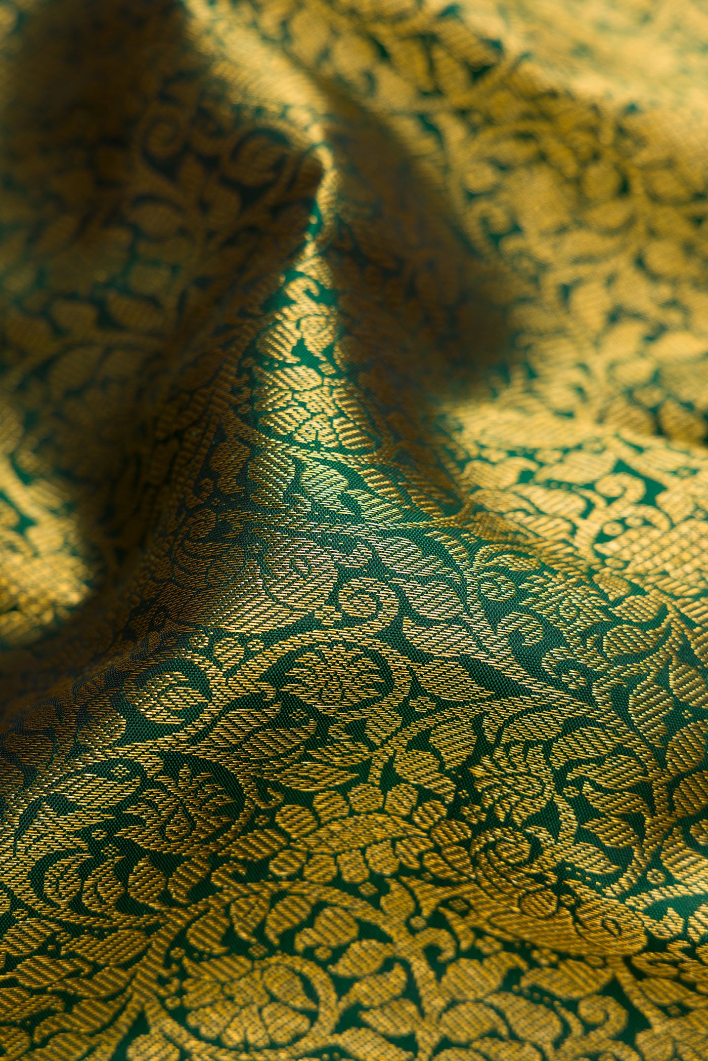Close up of Bottle Green Dual Tone Kanjivaram Silk Saree with Zari Brocade on the body and Zari Border.  displaying folds