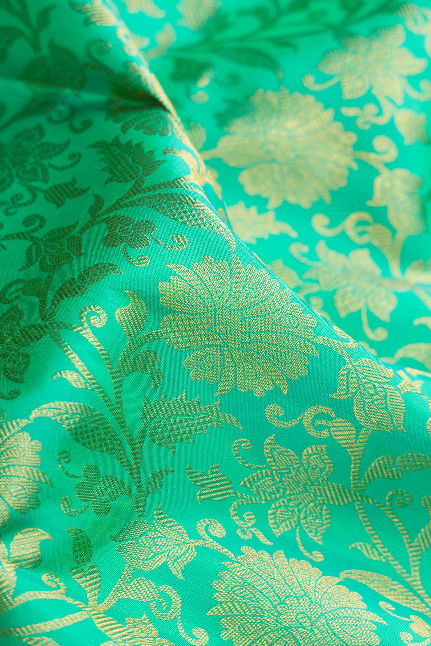 Close up of Sea Green Dual Tone Kanjivaram Silk Saree with Zari Brocade on the body and Zari Border.  displaying folds