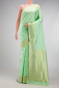 Pista Green Kanchipuram Silk Saree with Zari Butta on the body and Zari Border.  displayed on a mannequin