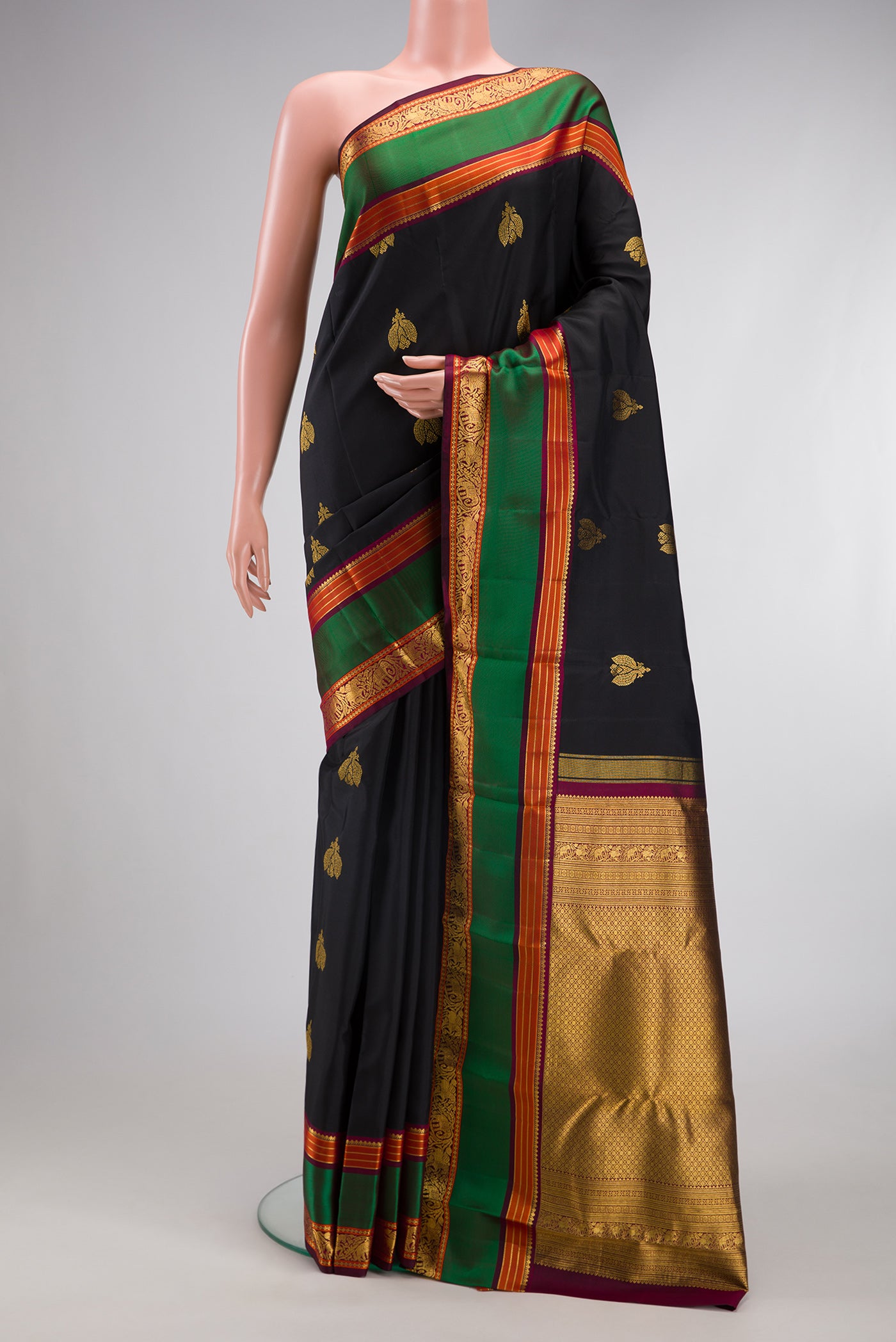 Black Kanjivaram Silk Saree with Zari Butta on the body and Zari And Thread Border.  displayed on a mannequin