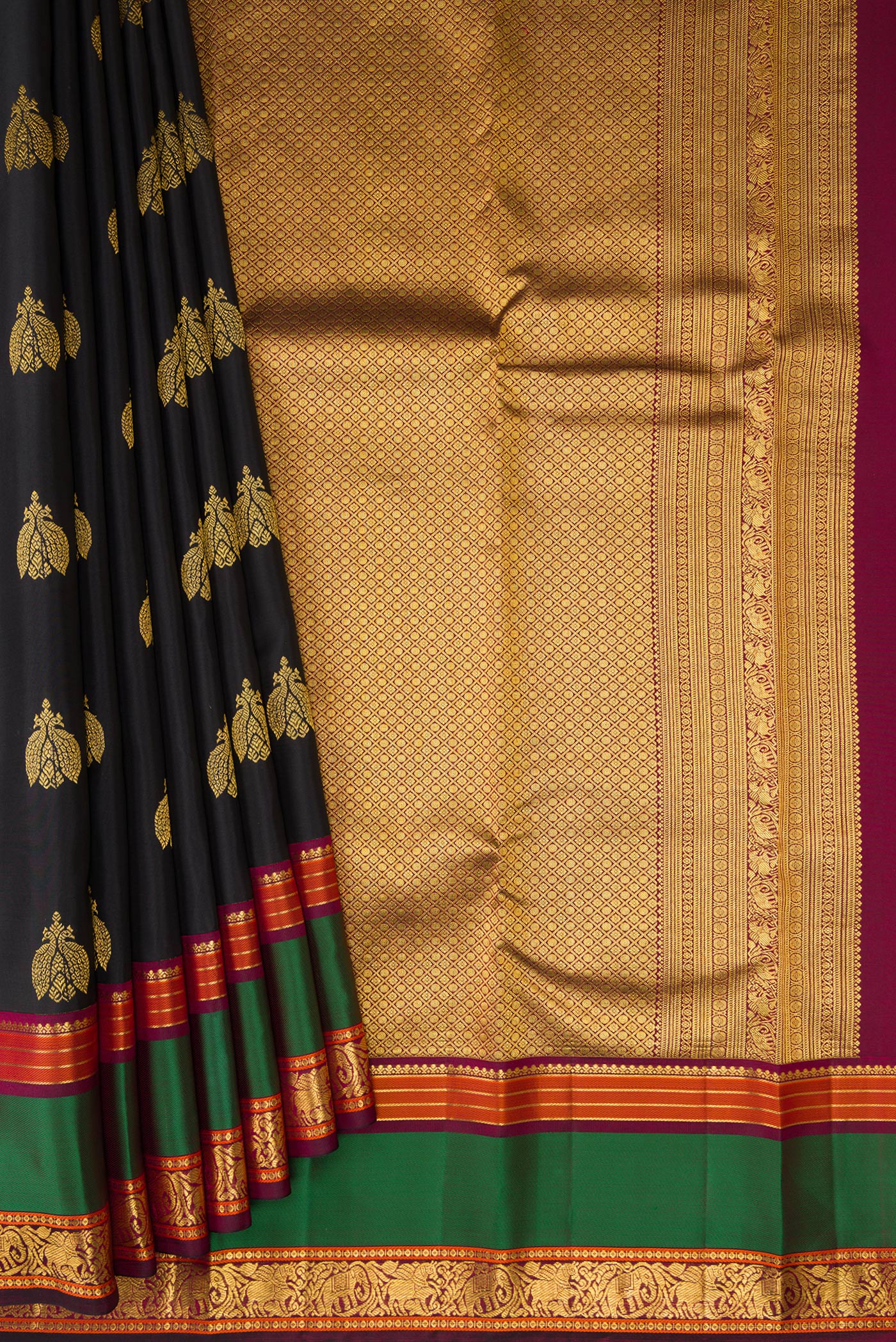 Pleats and pallu of Black Kanjivaram Silk Saree with Zari Butta on the body and Zari And Thread Border. 