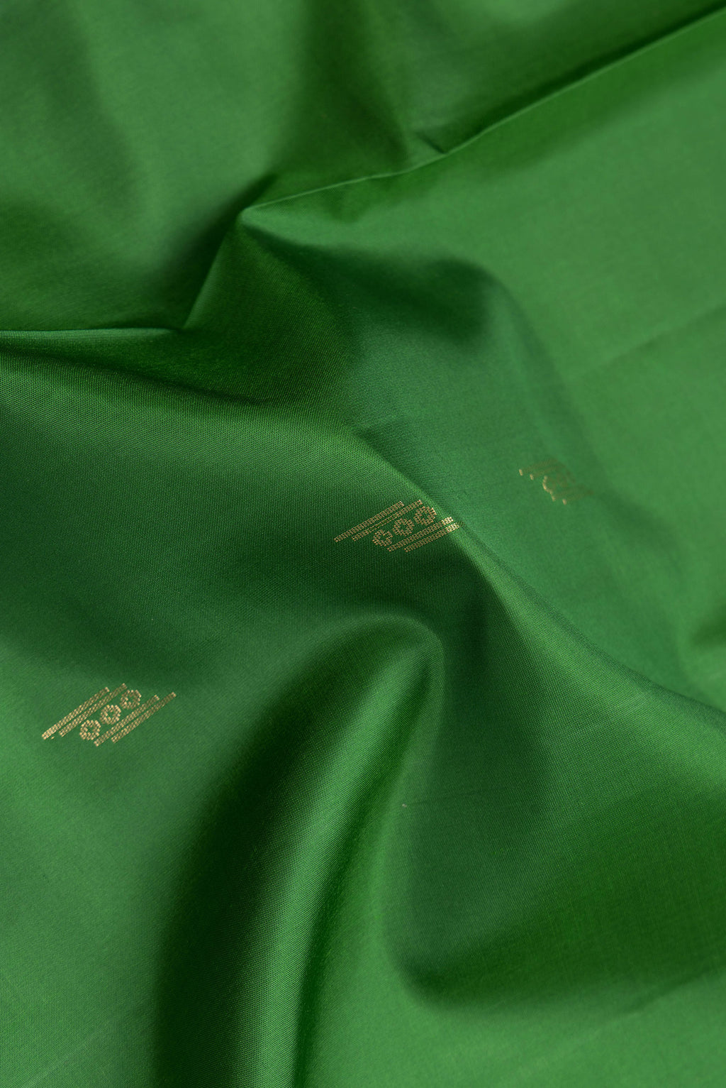 Close up of Green Dual Tone Soft Silk Saree with Zari Butta on the body and Zari Border.  displaying folds