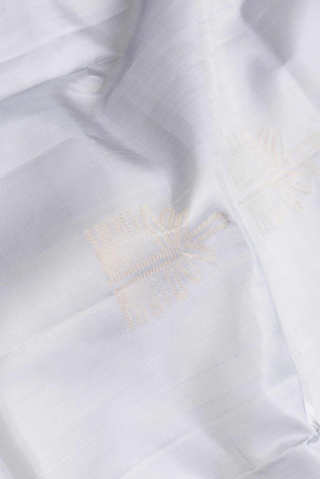 Close up of Grey Dual Tone Soft Silk Saree with Zari Butta on the body and Zari Border.  displaying folds