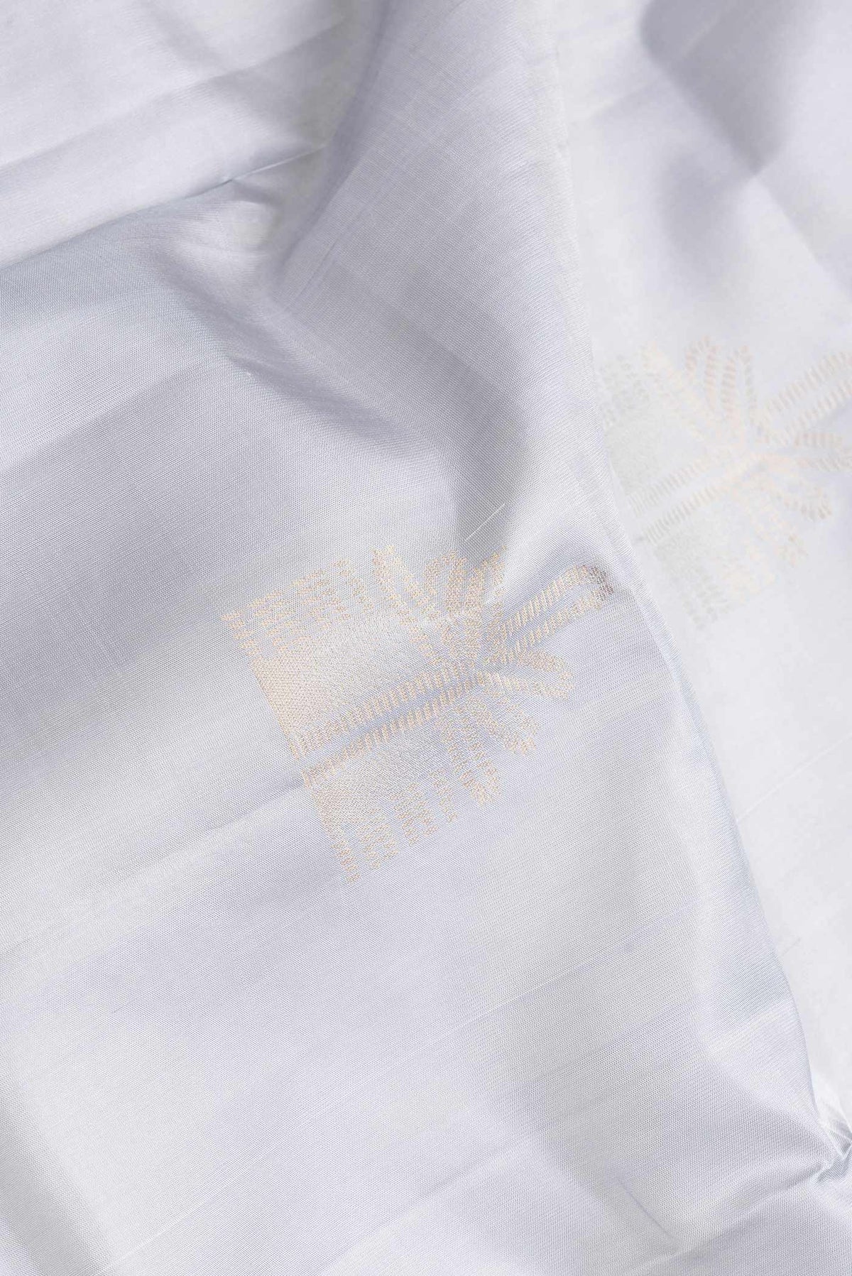 Close up of Grey Dual Tone Soft Silk Saree with Zari Butta on the body and Zari Border.  displaying folds