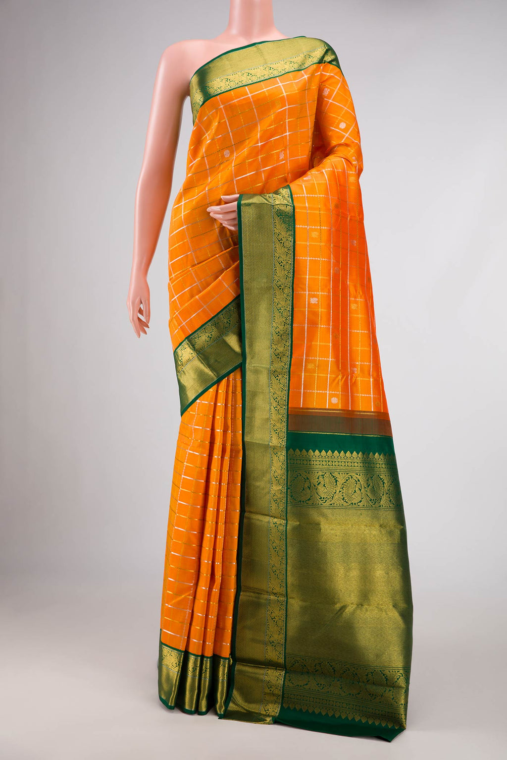 Orange Dual Tone Kanjivaram Silk Saree with Checked design on the body and Zari Border.  displayed on a mannequin